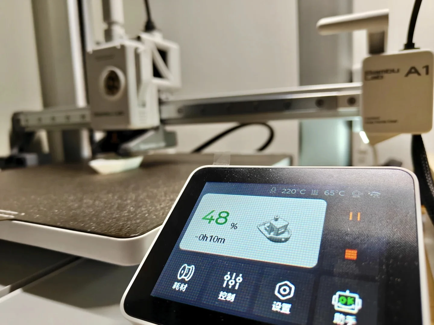 Close-up of a Bambu Lab A1 3D printer touchscreen showing a print progress of 48% for a miniature boat model, with the print head and build plate visible in the background.