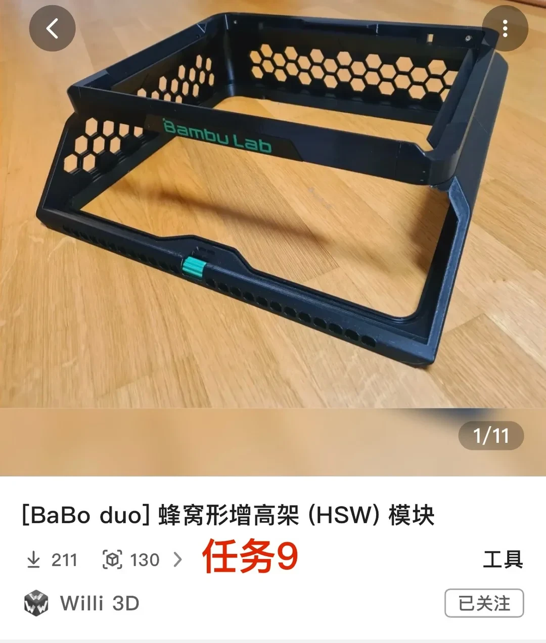 Product listing interface for a 3D printable design, featuring a photo of a black plastic honeycomb riser frame with green "Bambu Lab" lettering resting on a wooden floor. Below the photo are details including the model title, download statistics, category, and creator profile.