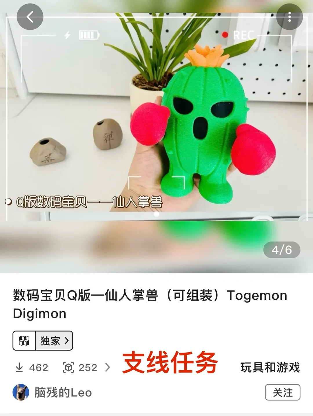 A product listing screenshot showcasing a green 3D-printed Togemon figure from Digimon, complete with red boxing gloves and an orange blossom on its head. The figure is held in a person's hand against a white desk with small potted plants and stones. Below the photo, the listing details display title text, an exclusive tag, statistics, and creator information.