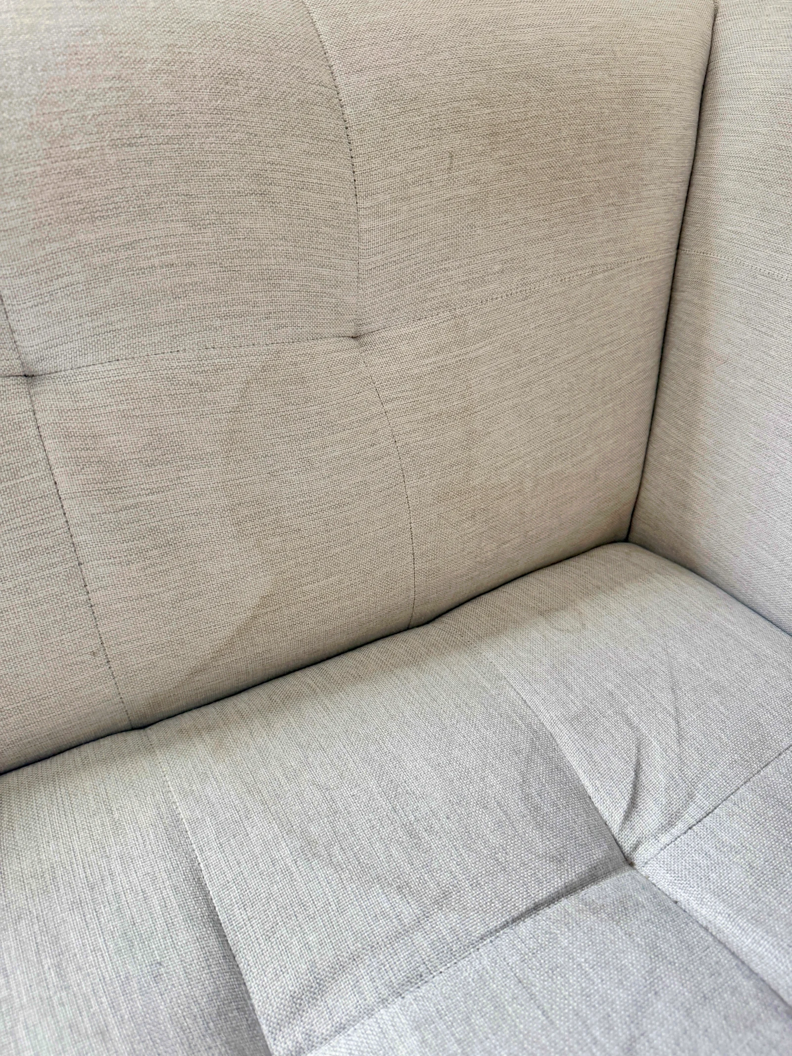 A closer view of marks on the pale sofa.