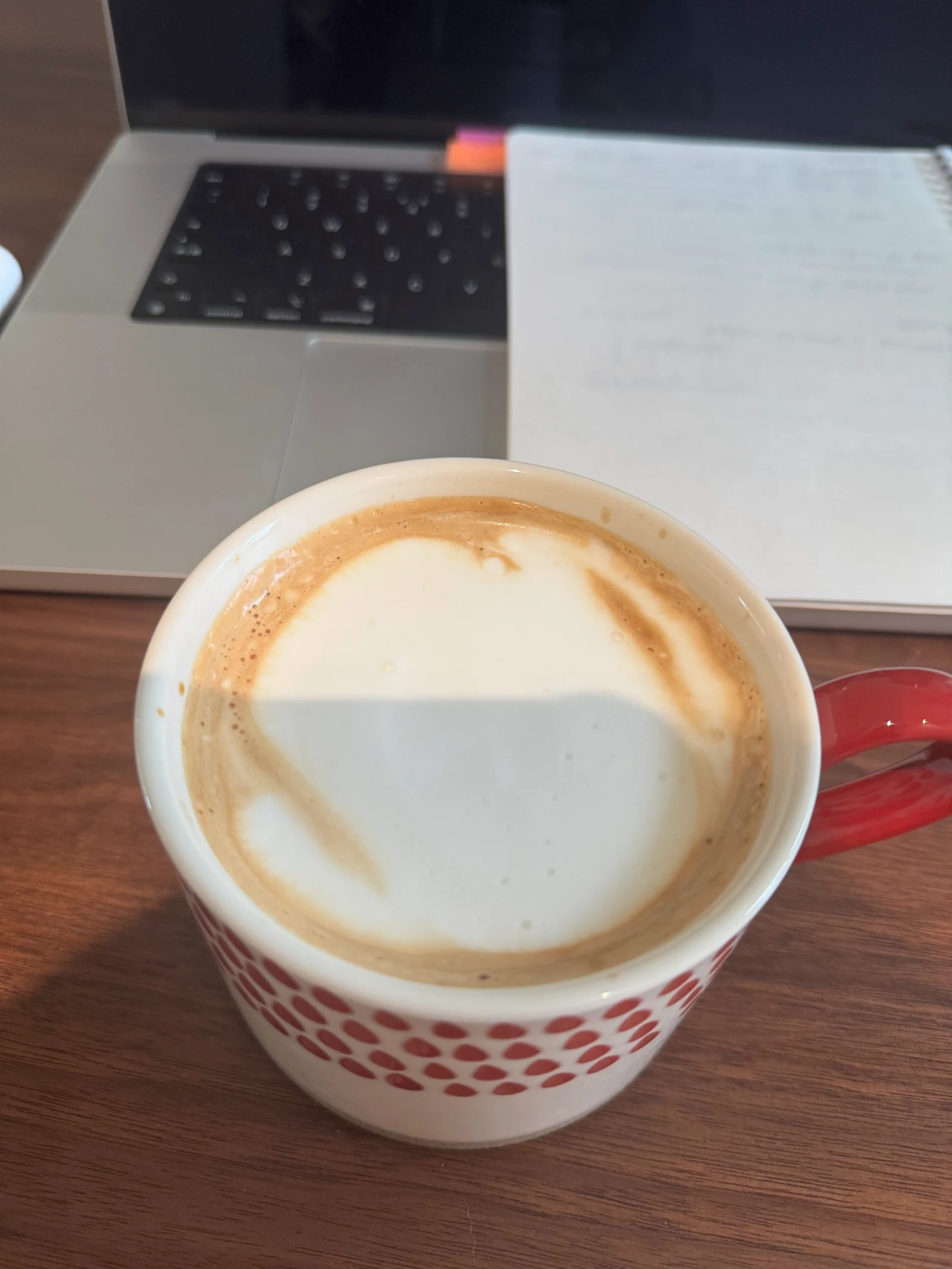 The owner’s milk coffee beside a laptop.
