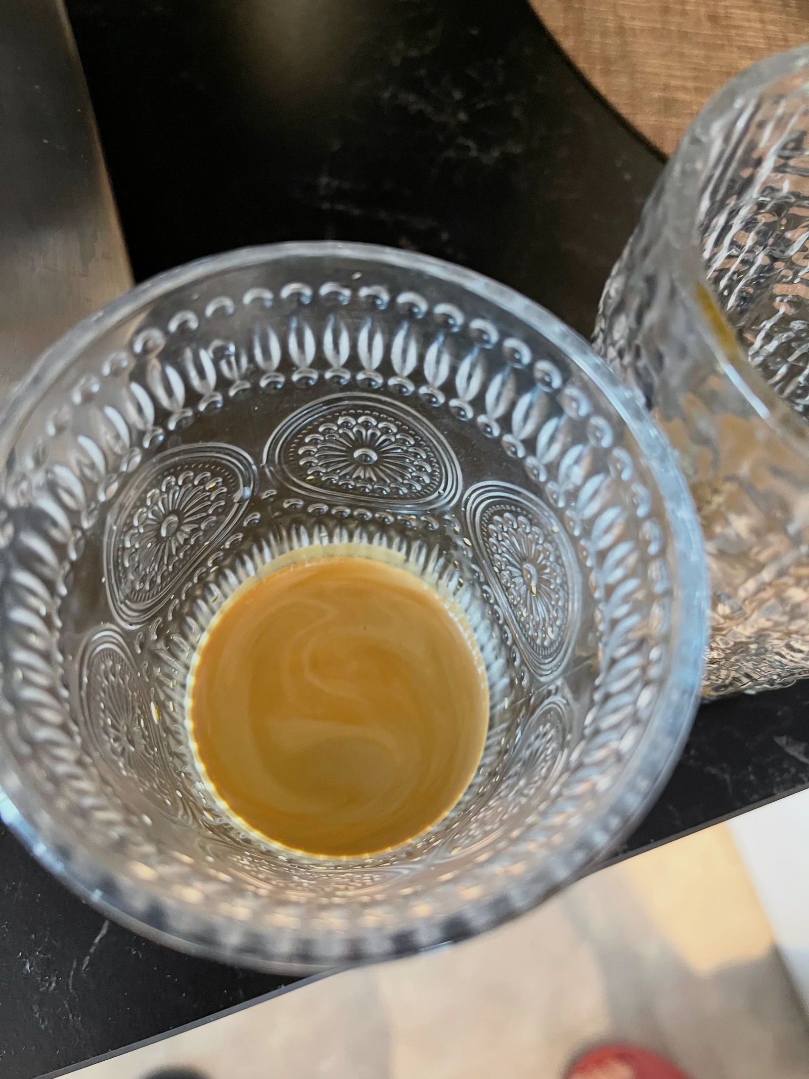 Crema on the espresso in a patterned glass.