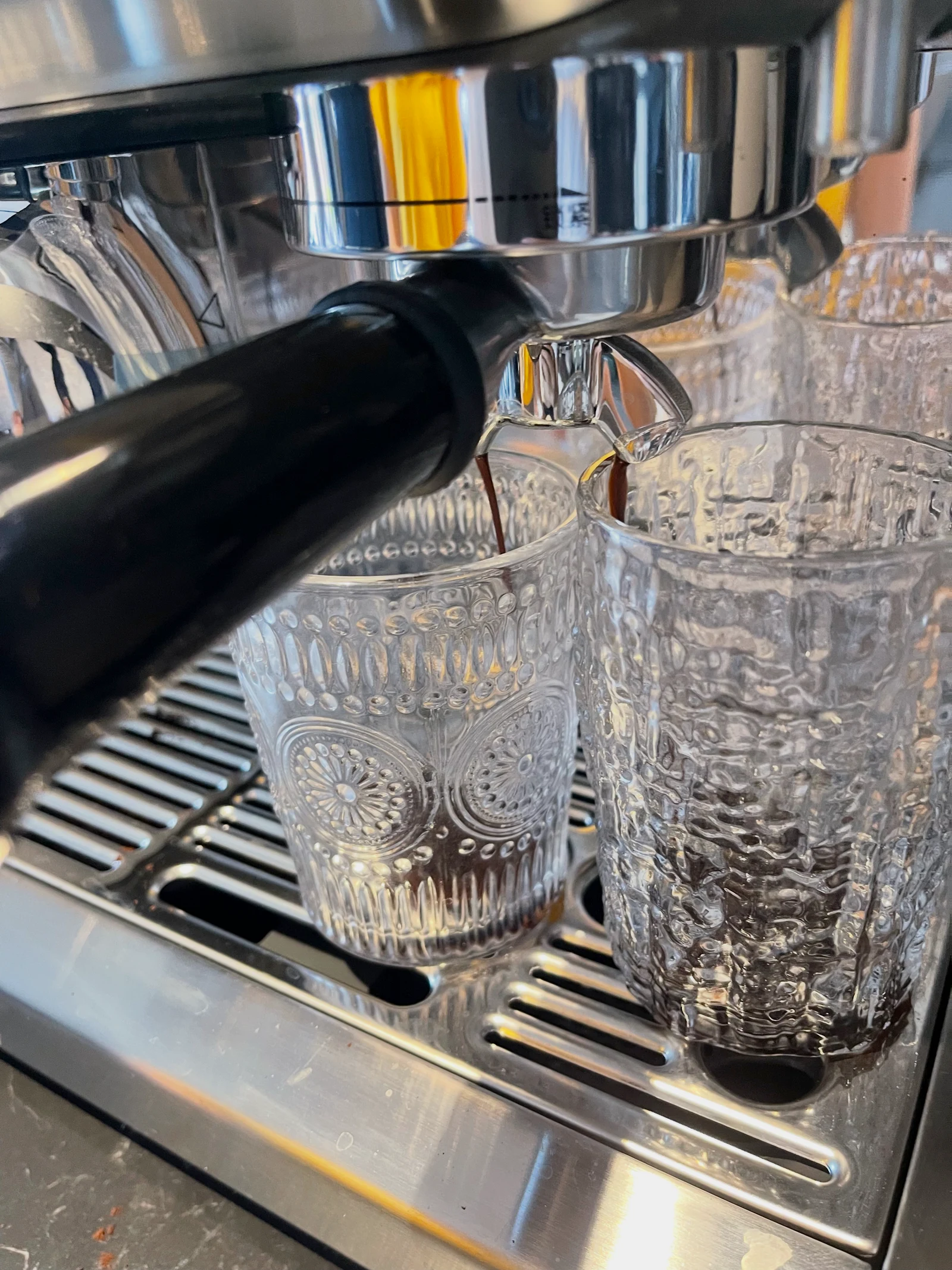 Espresso beginning to flow into the glasses.