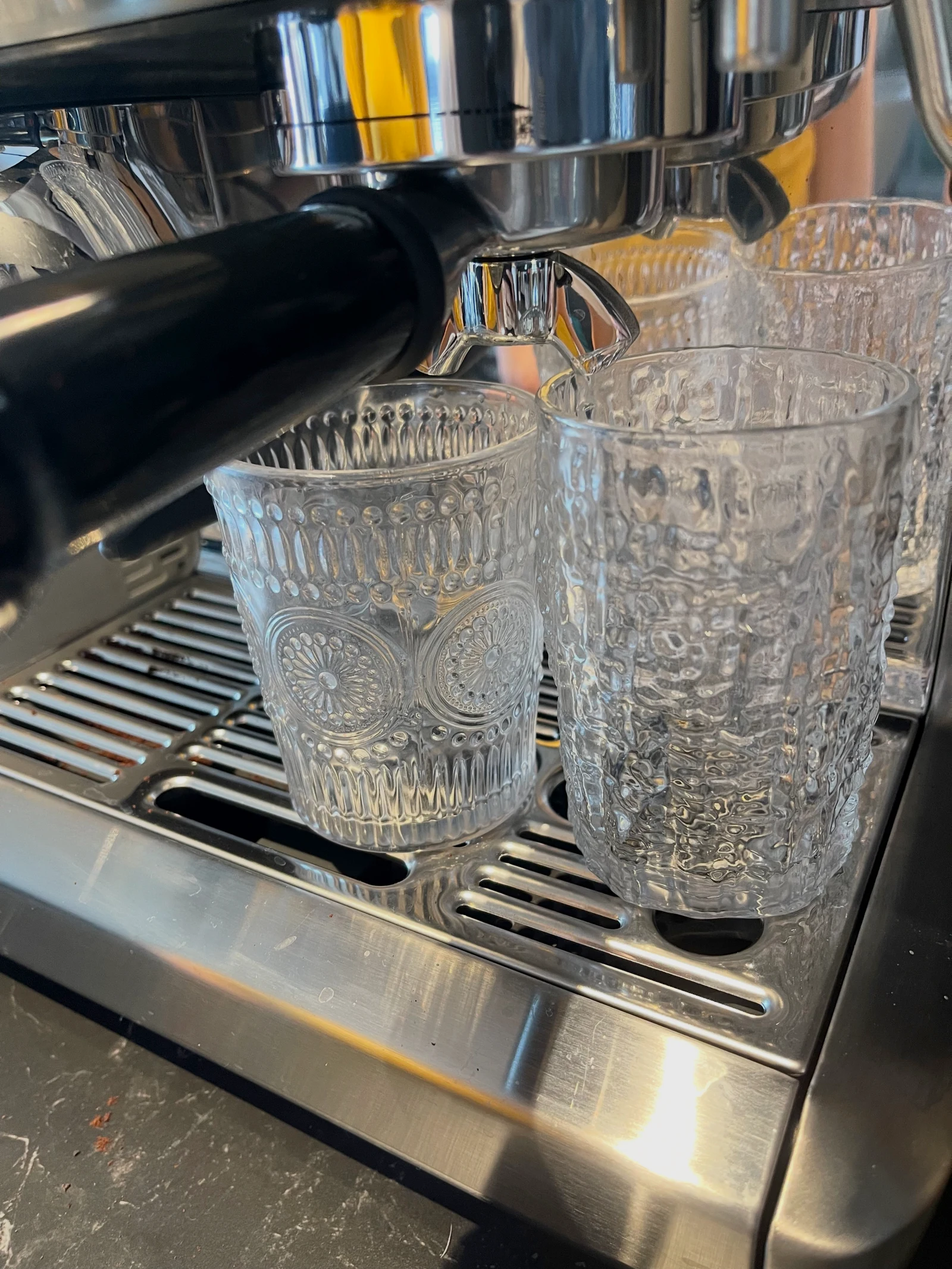 Two glasses beneath the portafilter at the start of a shot.