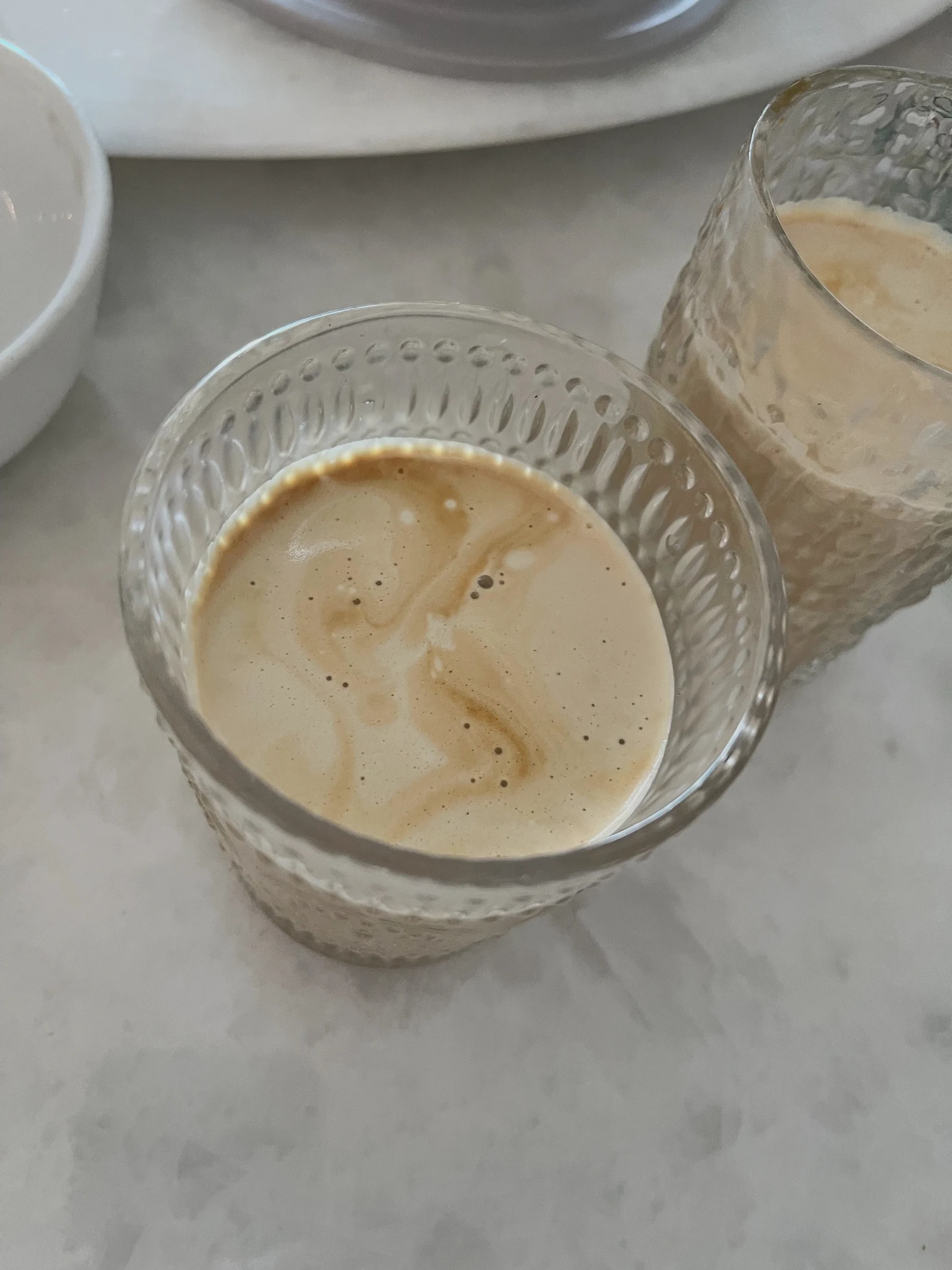 The owner’s milk coffee in the patterned glasses.