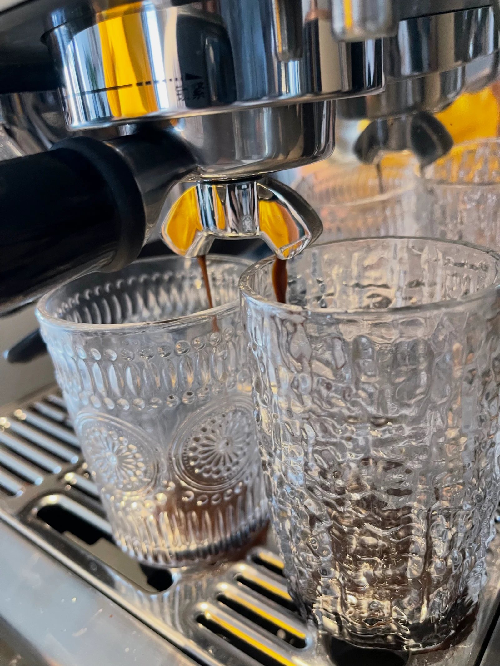 Espresso flowing from both portafilter spouts.