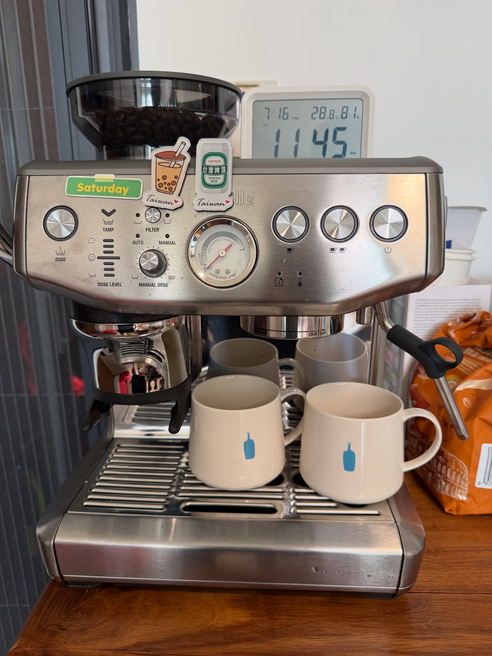 The machine with coffee cups, stickers and a small clock.