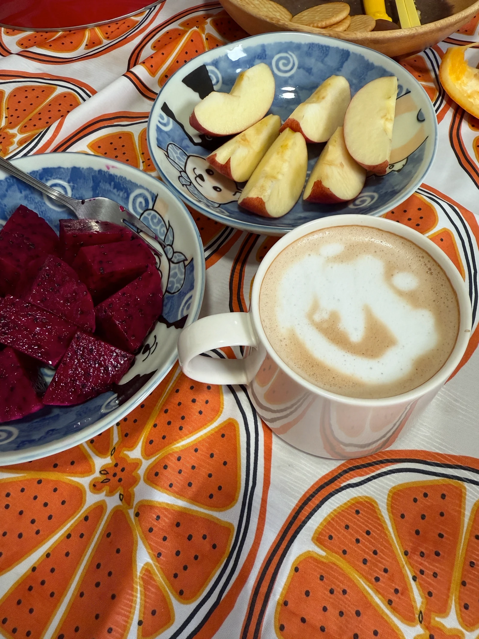 Milk coffee served with sliced fruit.