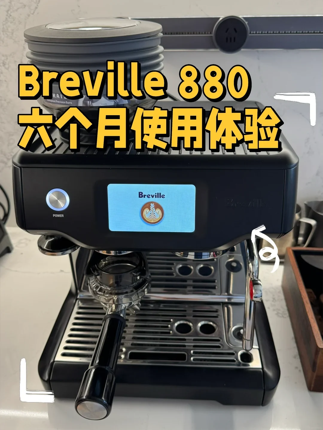 Black Breville 880 espresso machine on a countertop with a silicone bellows attachment on top, illuminated digital touchscreen, and portafilter docked underneath.