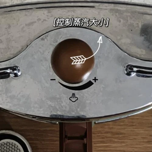 Close-up of a coffee machine’s top steam-control knob, marked with minus and plus symbols and an arrow indicating adjustment toward the plus side.