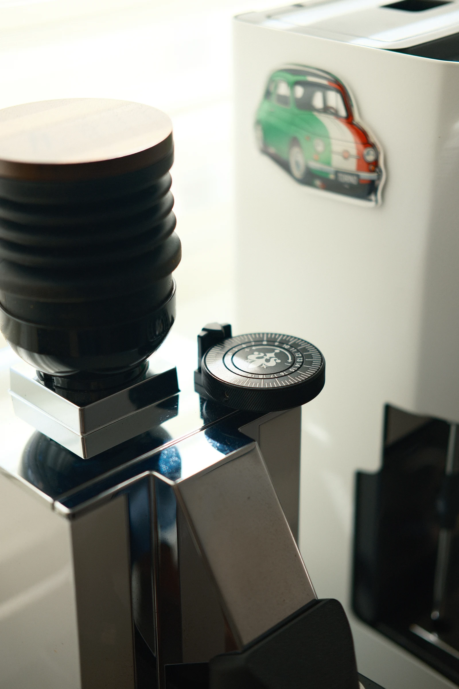 The grinder with its compact bellows hopper and adjustment dial.