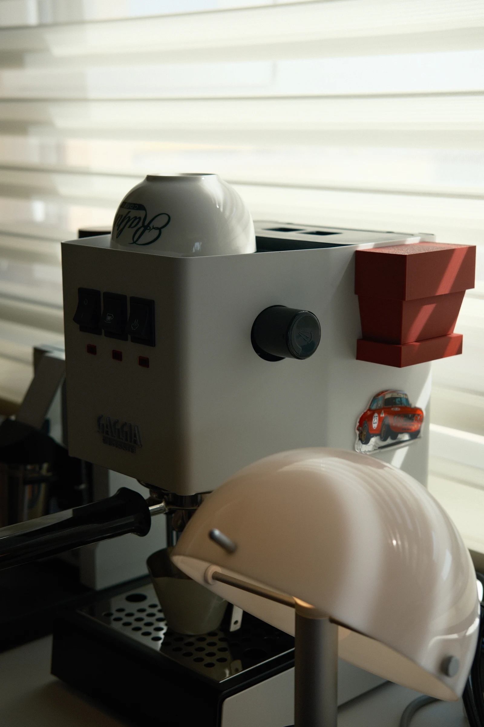 The compact coffee machine among the owner’s sideboard objects.
