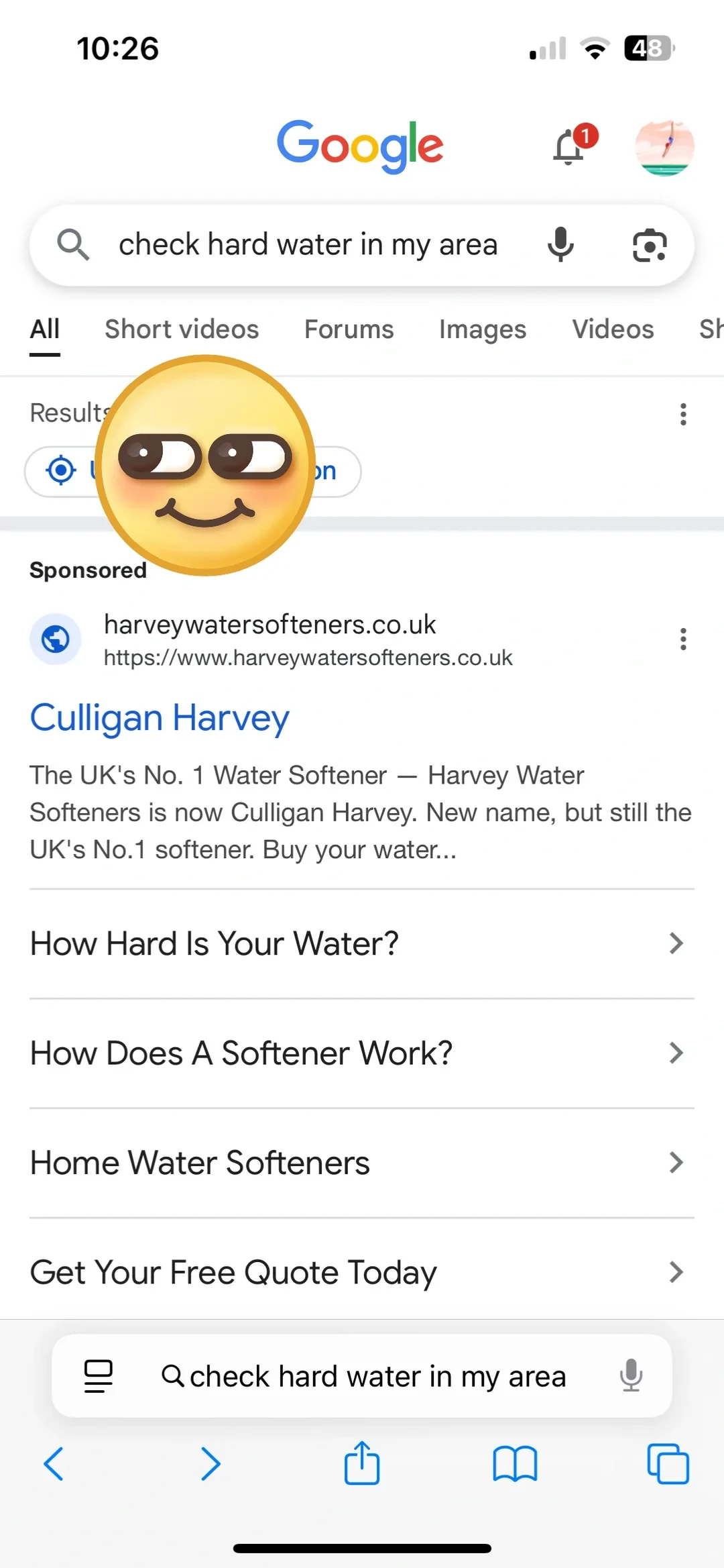 A screenshot of an iPhone screen displaying a Google search in a web browser for the phrase 'check hard water in my area'. Below the search bar is a sponsored link for Culligan Harvey water softeners, with an emoji sticker partially covering the upper-left section of the search results.