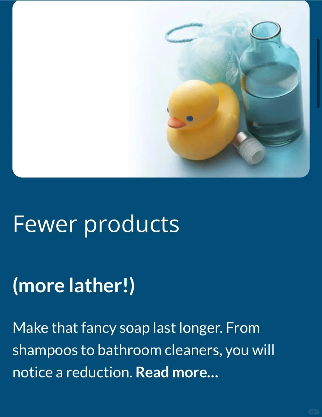 Bath-related items including a yellow rubber duck, a blue loofah, and a blue bottle filled with liquid against a white surface, set above an information card on a dark blue background with English text reading 'Fewer products (more lather!) Make that fancy soap last longer. From shampoos to bathroom cleaners, you will notice a reduction. Read more...'.