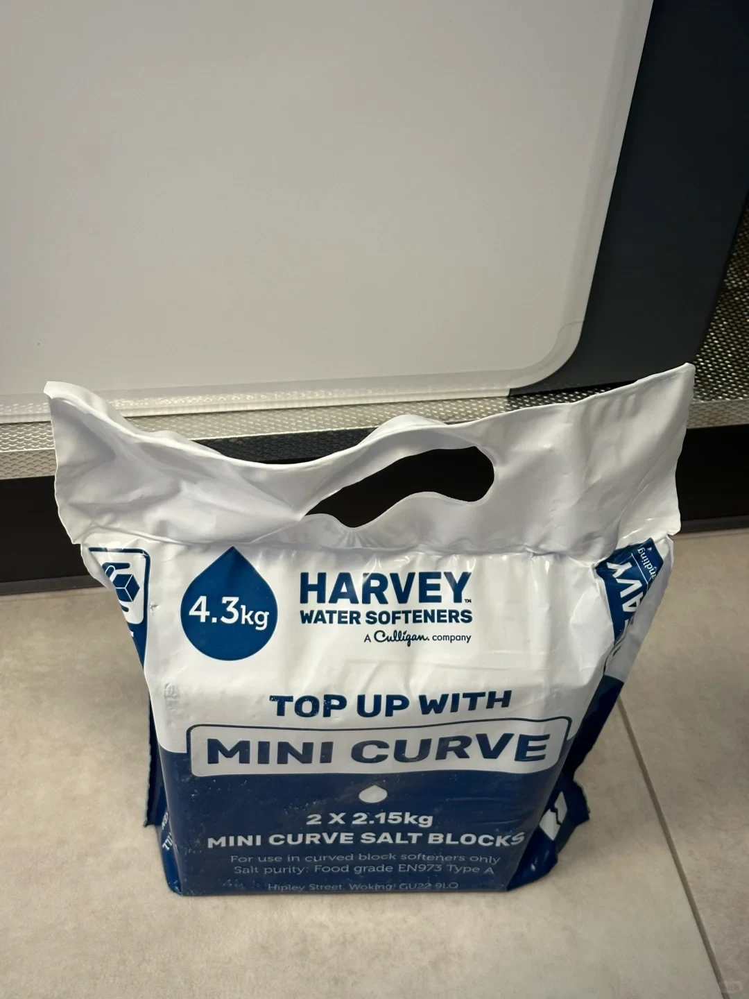 A 4.3 kg bag of Harvey Water Softeners Mini Curve salt blocks standing on a tiled floor.