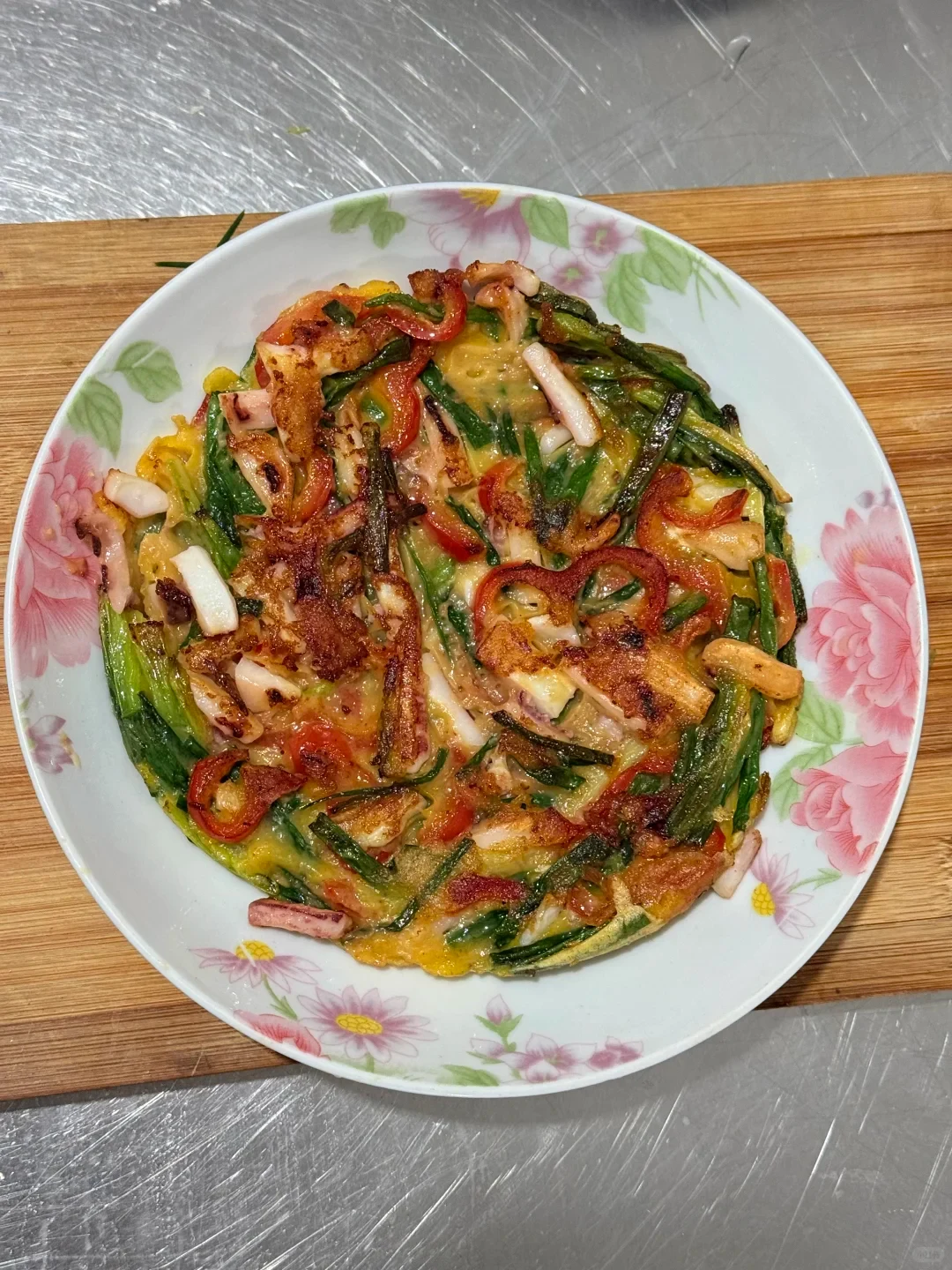 A cooked vegetable pancake on a floral ceramic plate.