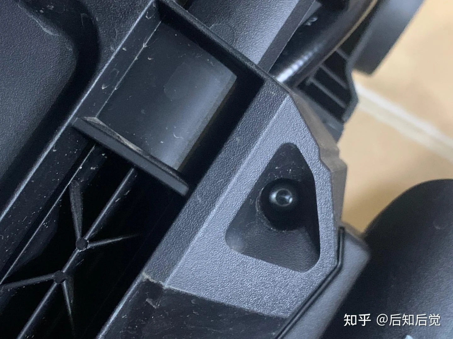 Close-up of a black Karcher pressure washer housing showing a recessed star-shaped screw beside a vent grille.