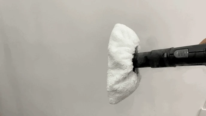 Hand nozzle of the Kärcher steam cleaner fitted with a white microfiber towel cover held up against a plain white background.