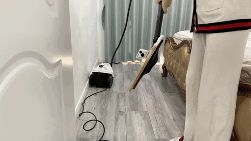 A person lifting the floor head of the Kärcher steam cleaner to show the attached microfiber cloth.