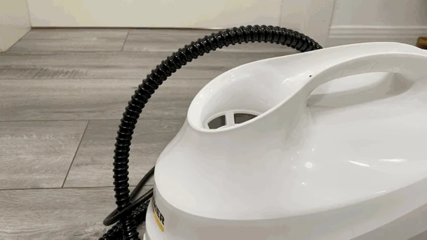 Top view of the white Kärcher steam cleaner showing its funnel-shaped water inlet and carry handle on a wood-look floor.