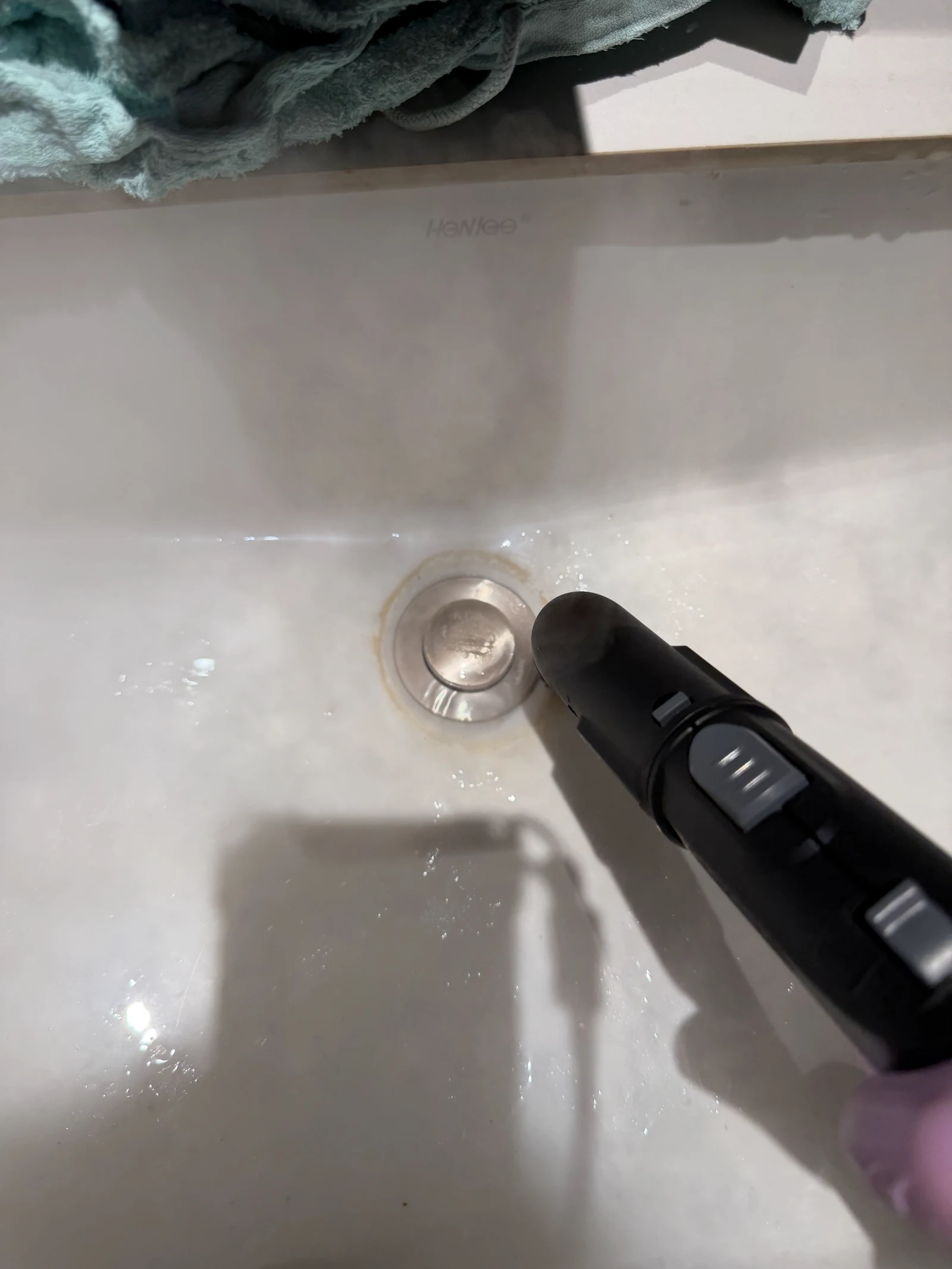 Steam directed at scale around a basin drain.