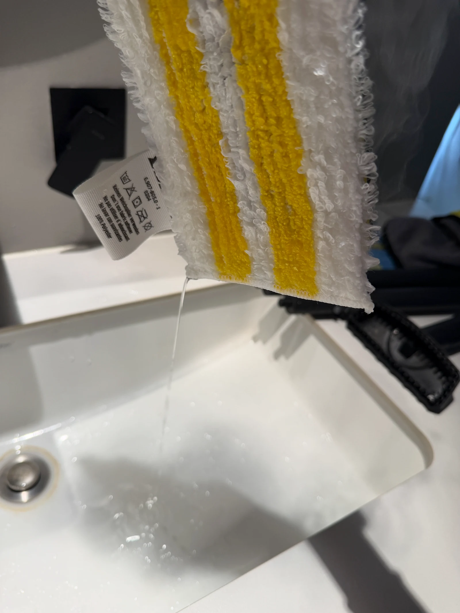 The steam-mop cloth dripping above a basin.