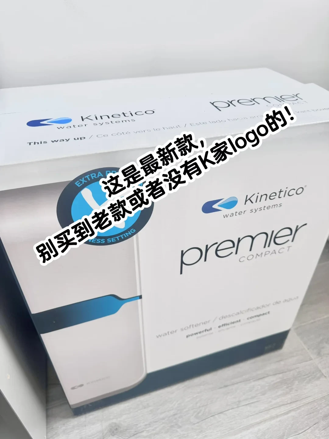 Packaging box for a Kinetico Premier Compact water softener with an overlaid Chinese caption.