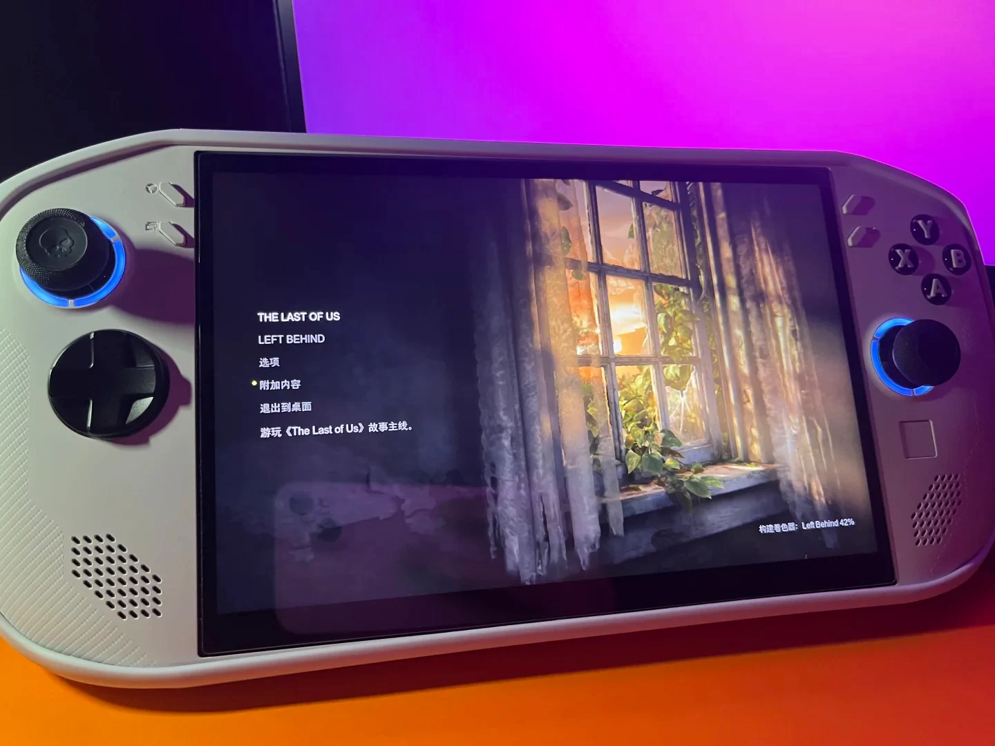 A white handheld gaming console displaying the Chinese main menu of The Last of Us: Left Behind.