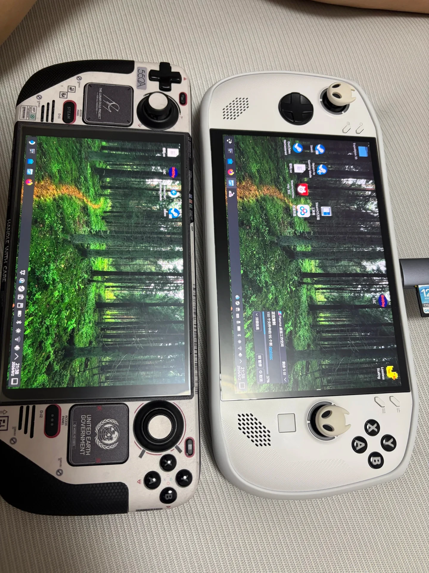 A skinned Steam Deck and a white Lenovo Legion Go S side by side, both displaying a Linux desktop with a green forest wallpaper. A Lossless Scaling shortcut is visible on the Legion Go S desktop.