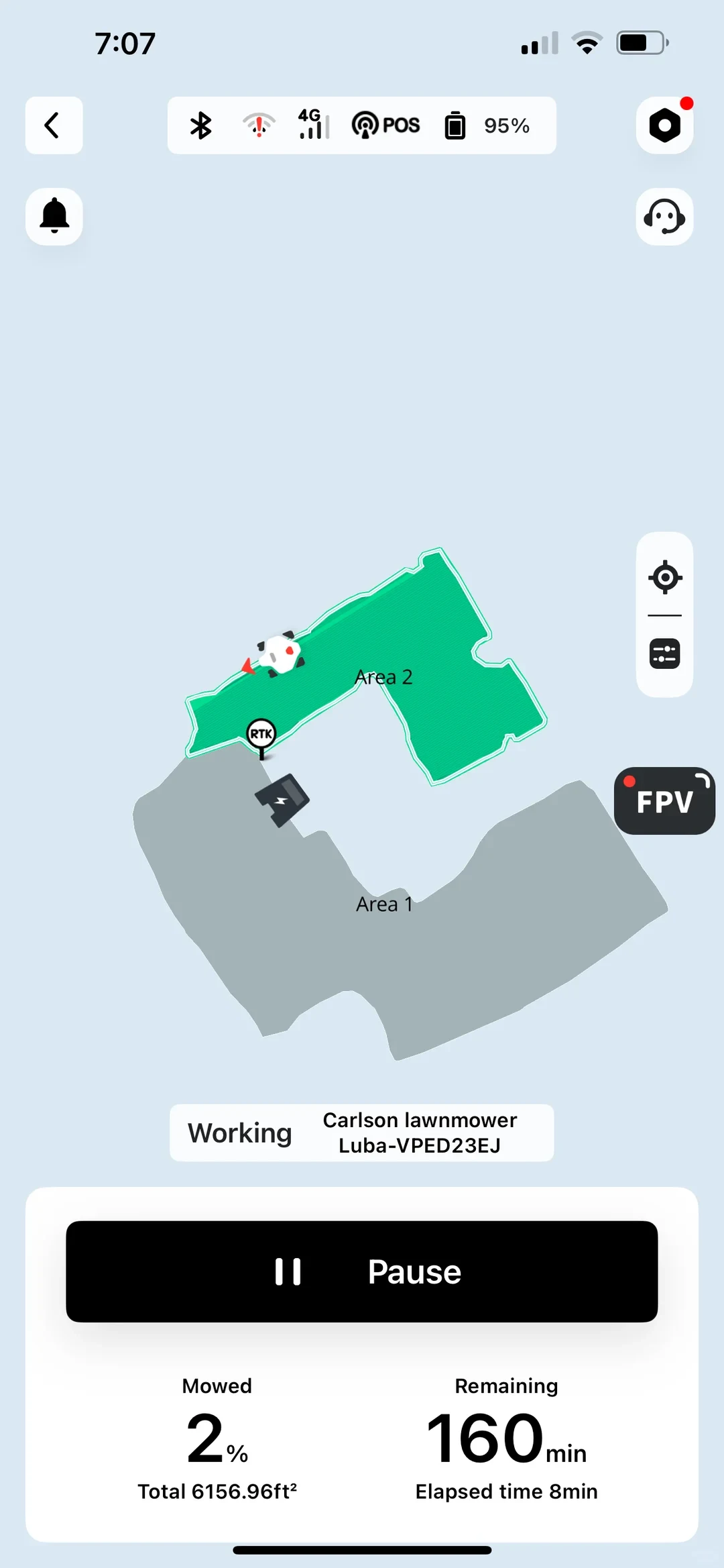 A mobile app interface displaying real-time tracking for an autonomous robotic lawnmower named Carlson lawnmower Luba-VPED23EJ. A map shows two designated lawn sections, Area 1 in gray and Area 2 highlighted in green, where the robot mower is actively operating. Icons mark the RTK station and charging dock. A bottom control panel features a prominent Pause button and statistics showing 2% mowed out of a total 6156.96 square feet, 160 minutes remaining, and an elapsed time of 8 minutes.