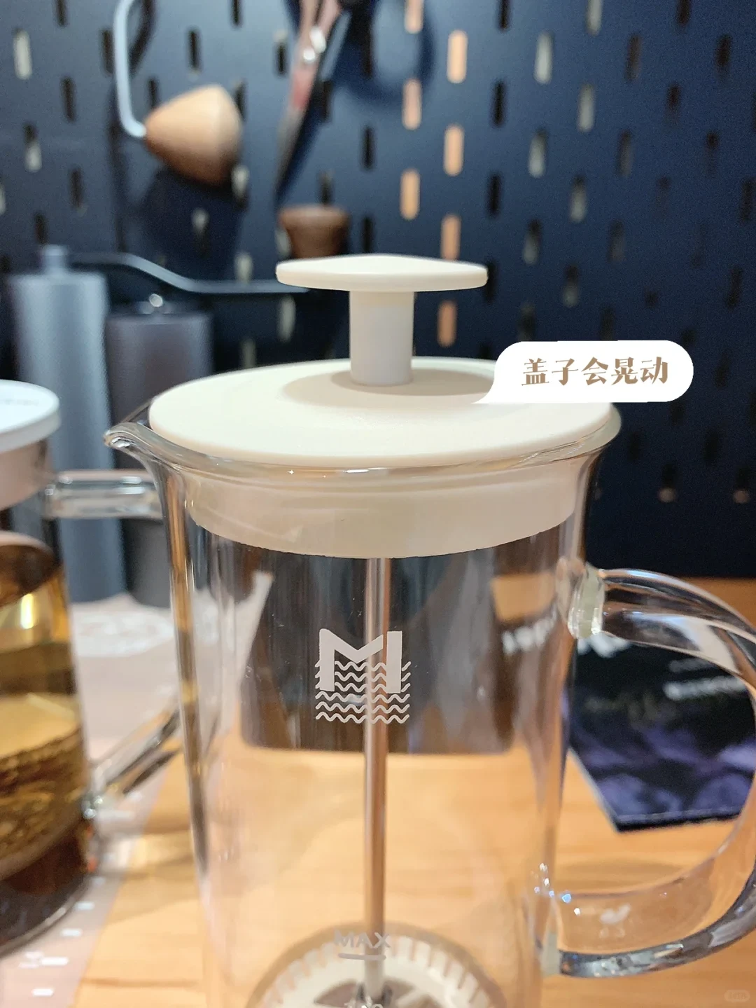 The owner’s MAVO Snow Meet milk foamer has a clear glass vessel and cream-colored plunger lid. The Chinese callout reports that the lid wobbles.