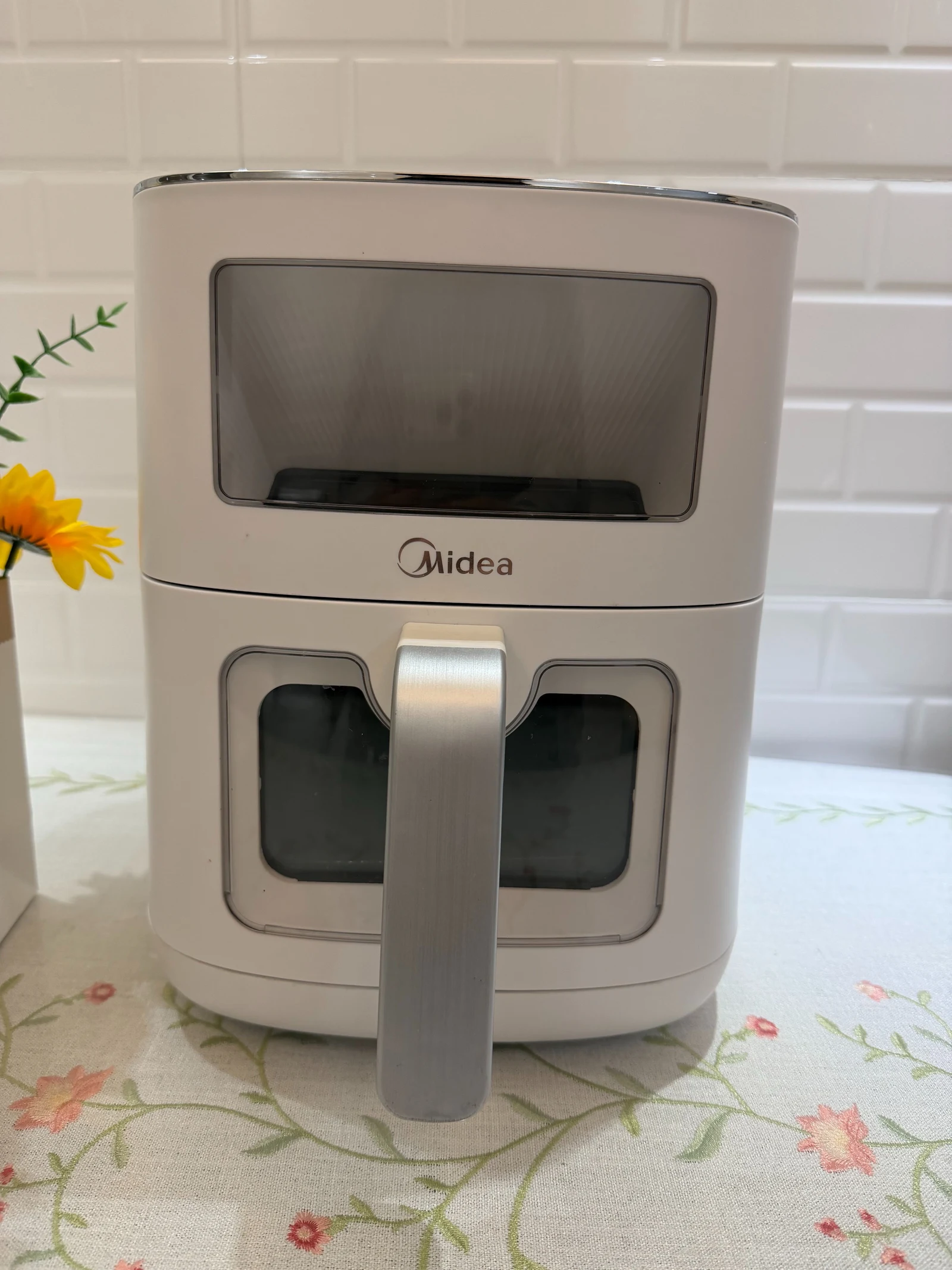 The pale Midea air fryer with an upper viewing window and a window in its basket.