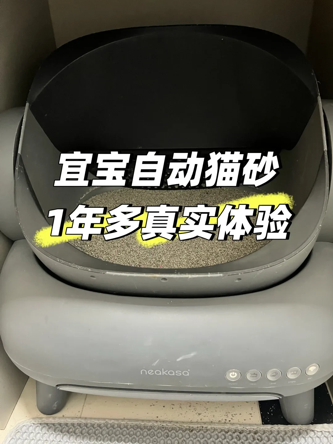 A Neakasa automatic cat litter box filled with litter, viewed from the front, with bold Chinese text overlaid across the center.