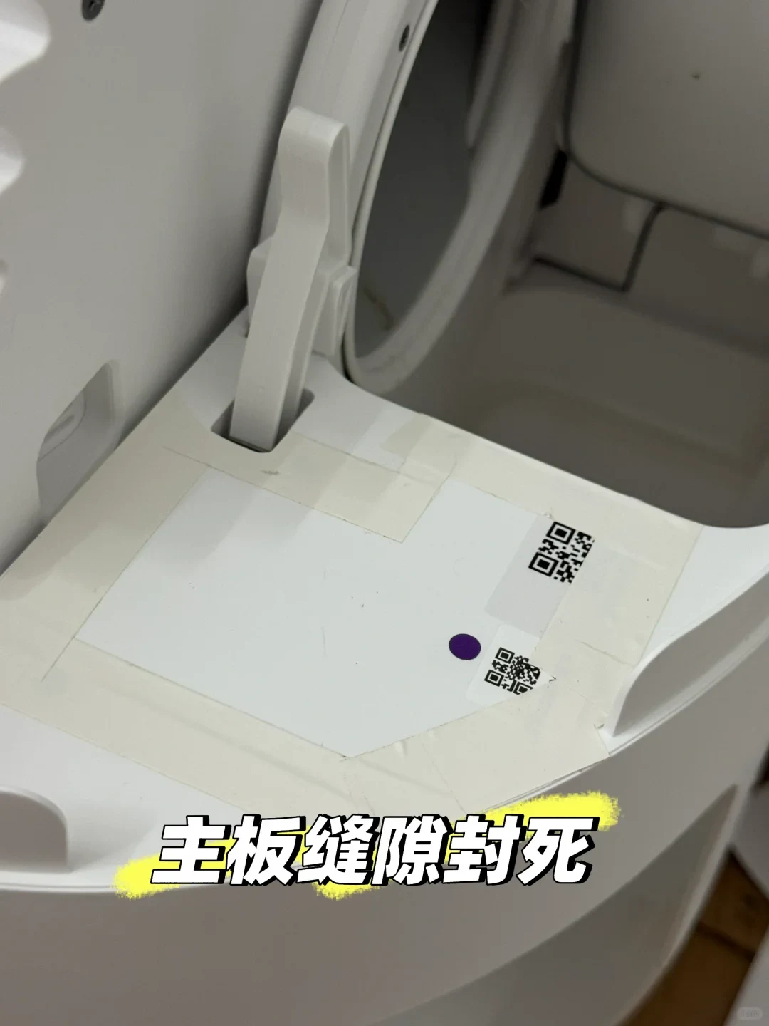 Close-up view of an opened white smart pet appliance, where a white cover with two QR codes and a purple dot is taped securely along all edges with light masking tape to seal the compartment. Overlaid text in bold with a yellow highlight is shown at the bottom.