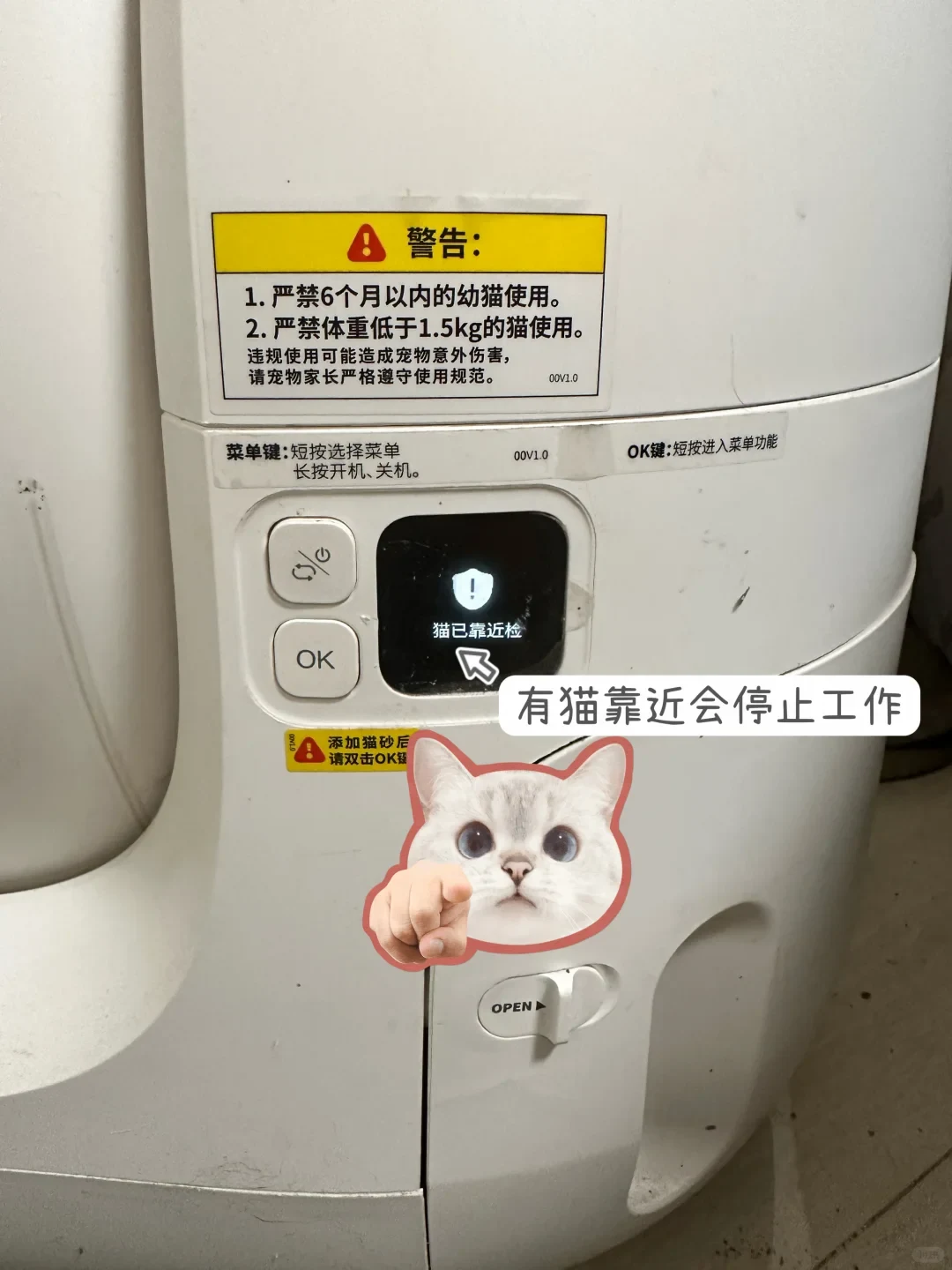 Close-up of the control panel on a white PETKIT automatic cat litter box, displaying a shield alert icon and Chinese notification on the small digital screen next to the OK button.