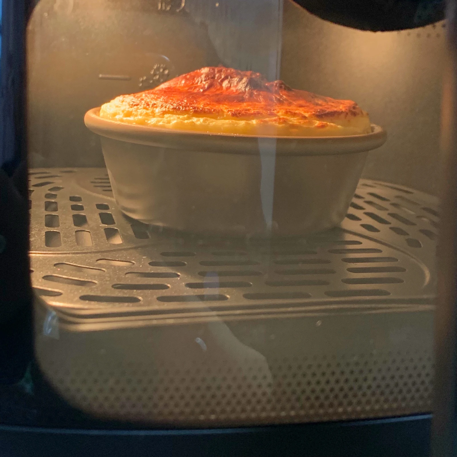 A rising cake seen through the cooking window.