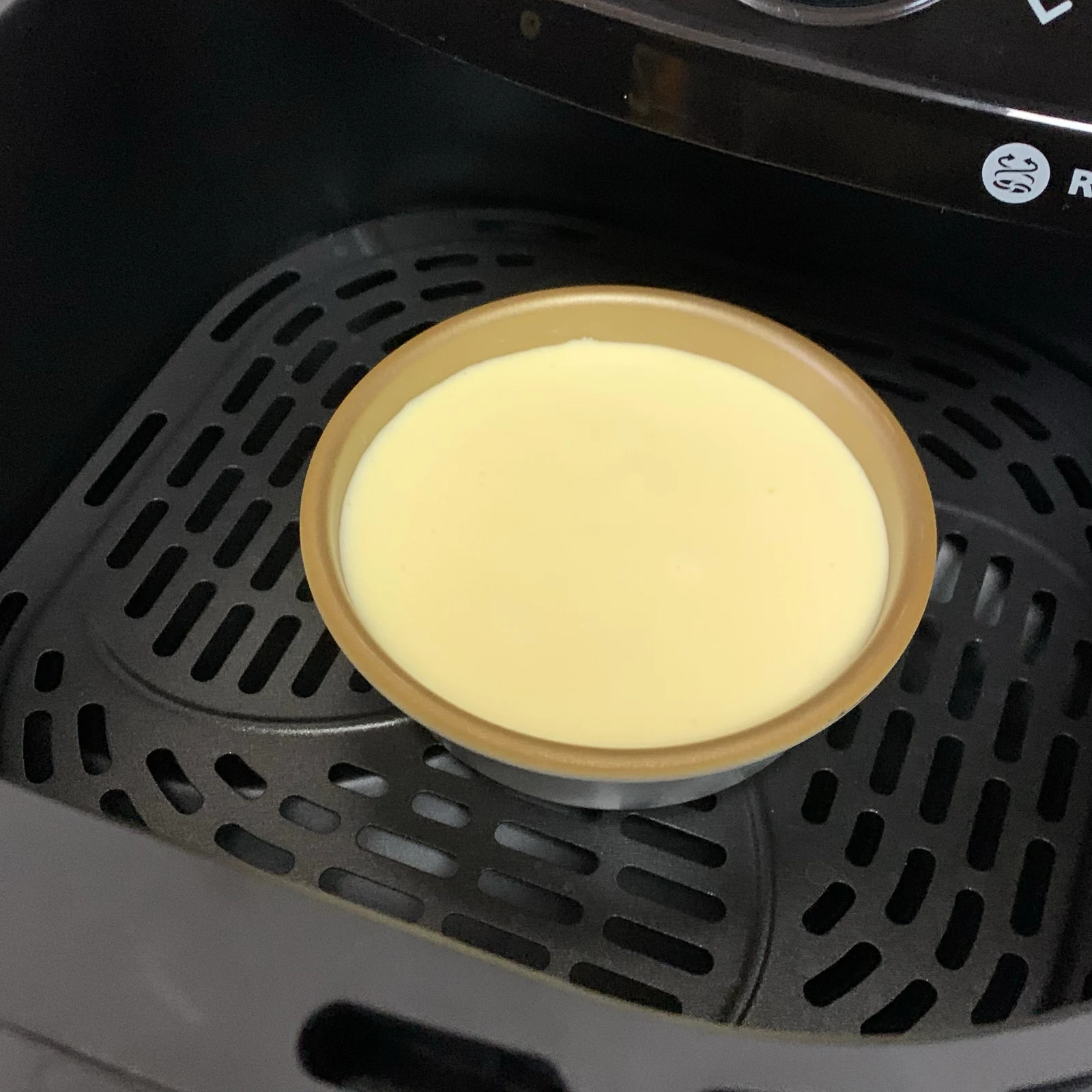 A cake tin filled with batter inside the NA230 basket.