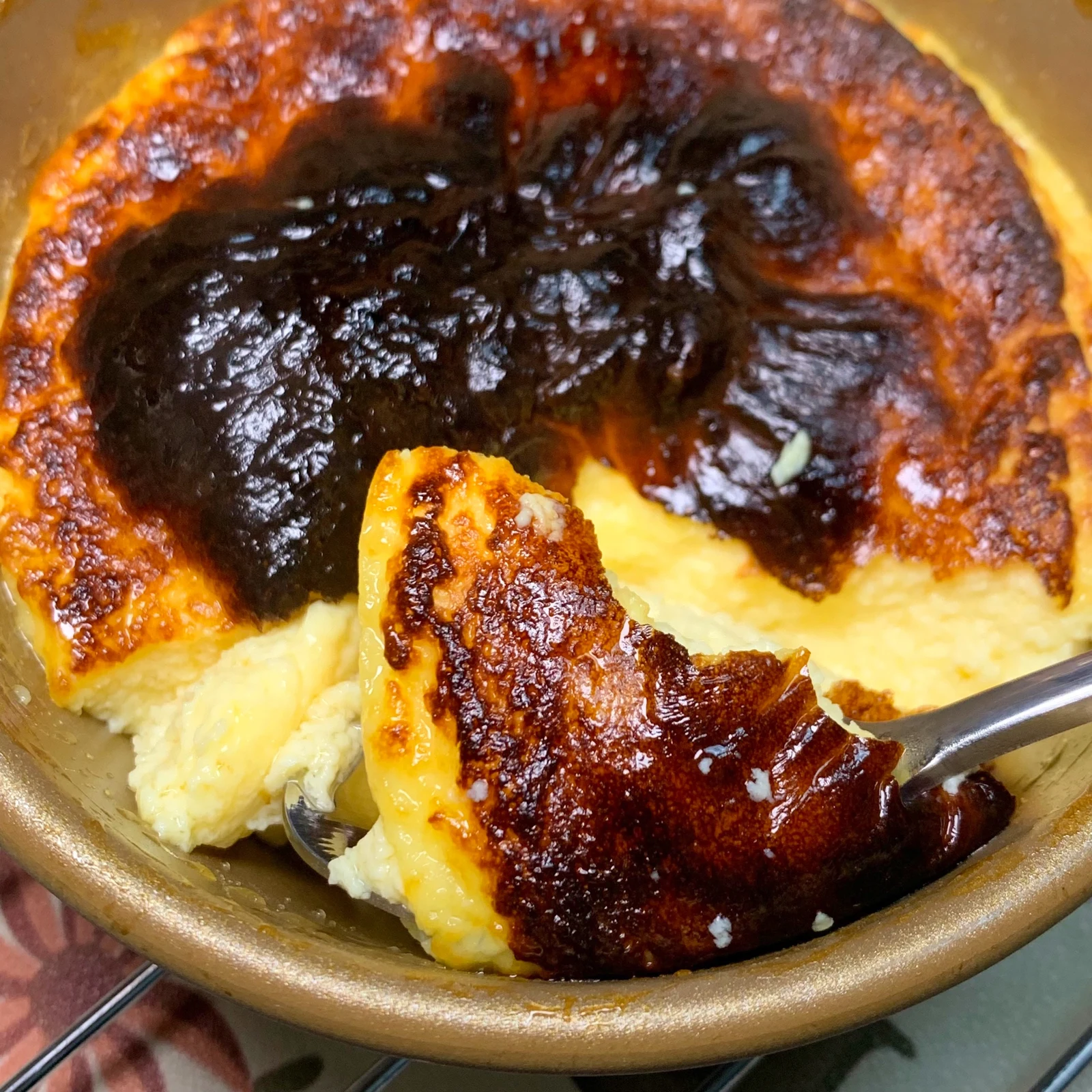 A spoon lifting a slice from the cheesecake.