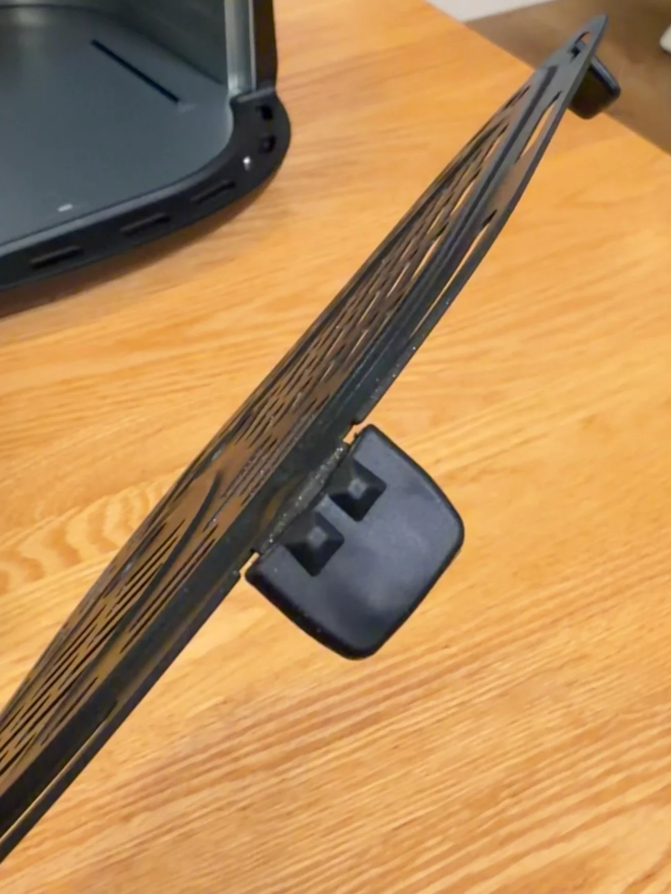 A side view of the removable cooking plate showing its raised feet.