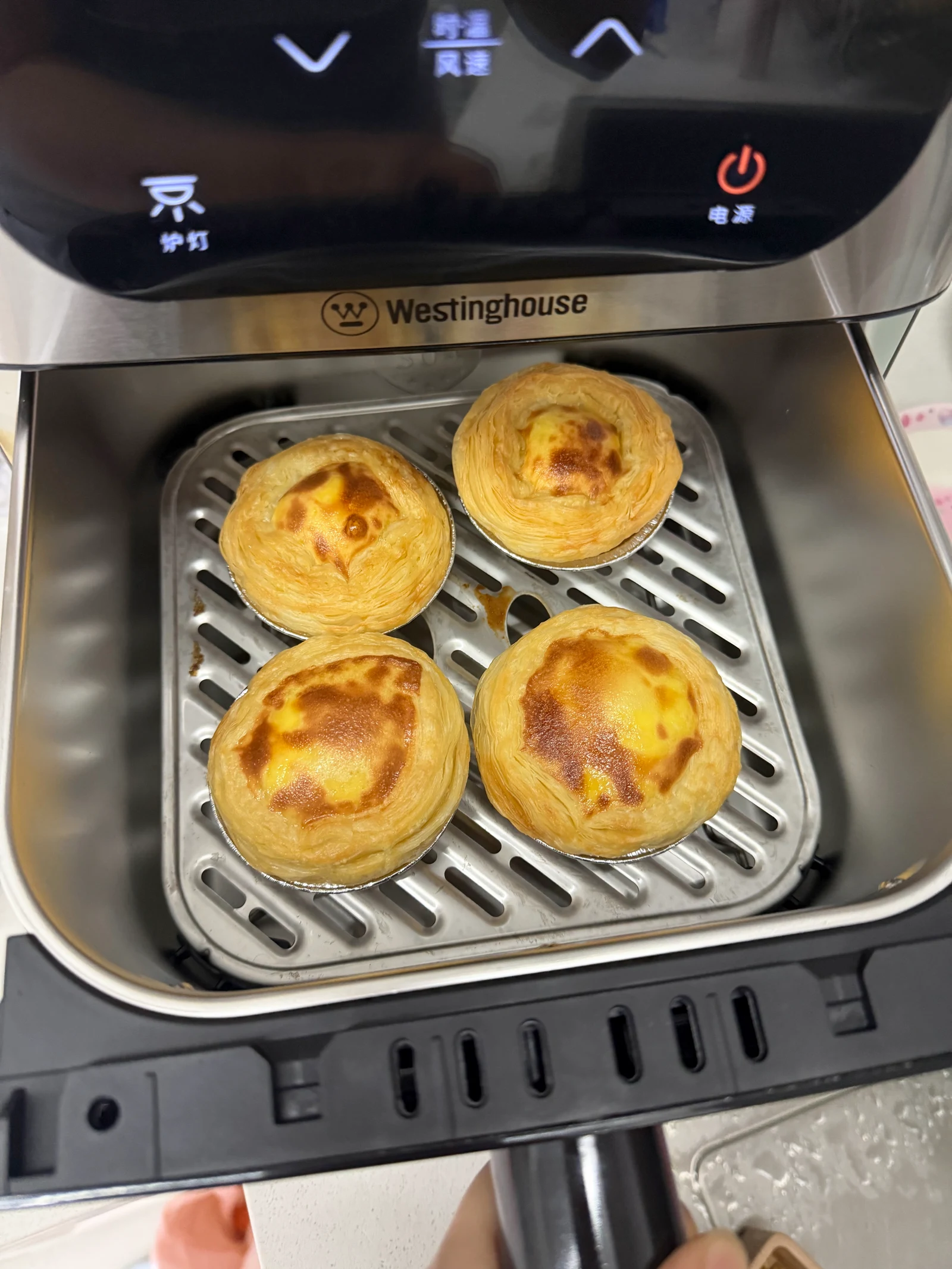 Four browned egg tarts in the H10U basket, shown by the owner as photo one.