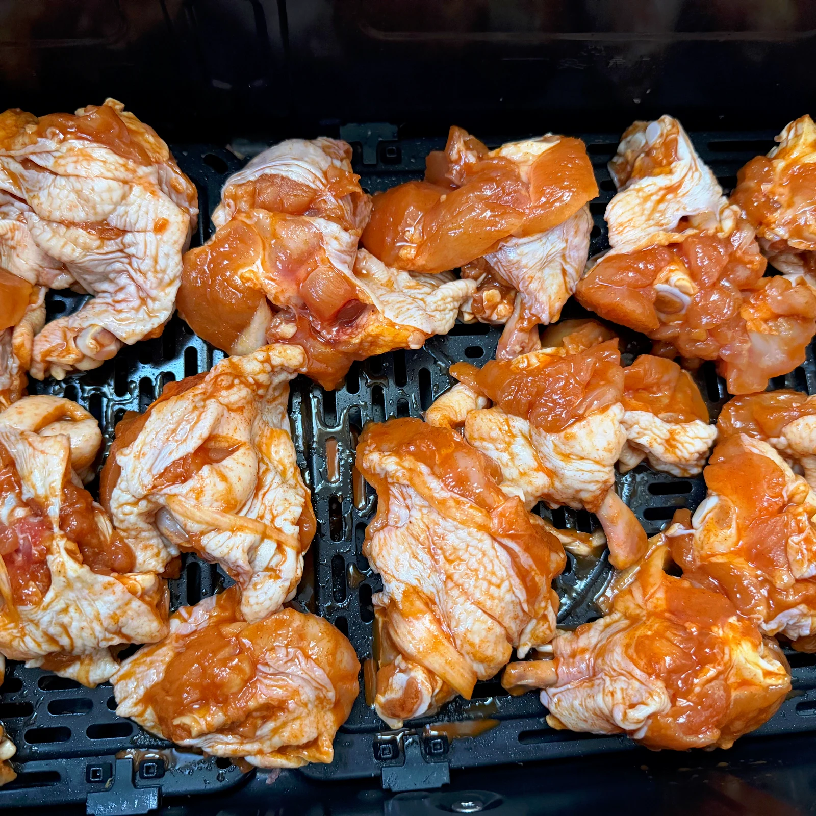 Marinated chicken drumettes arranged in the basket.