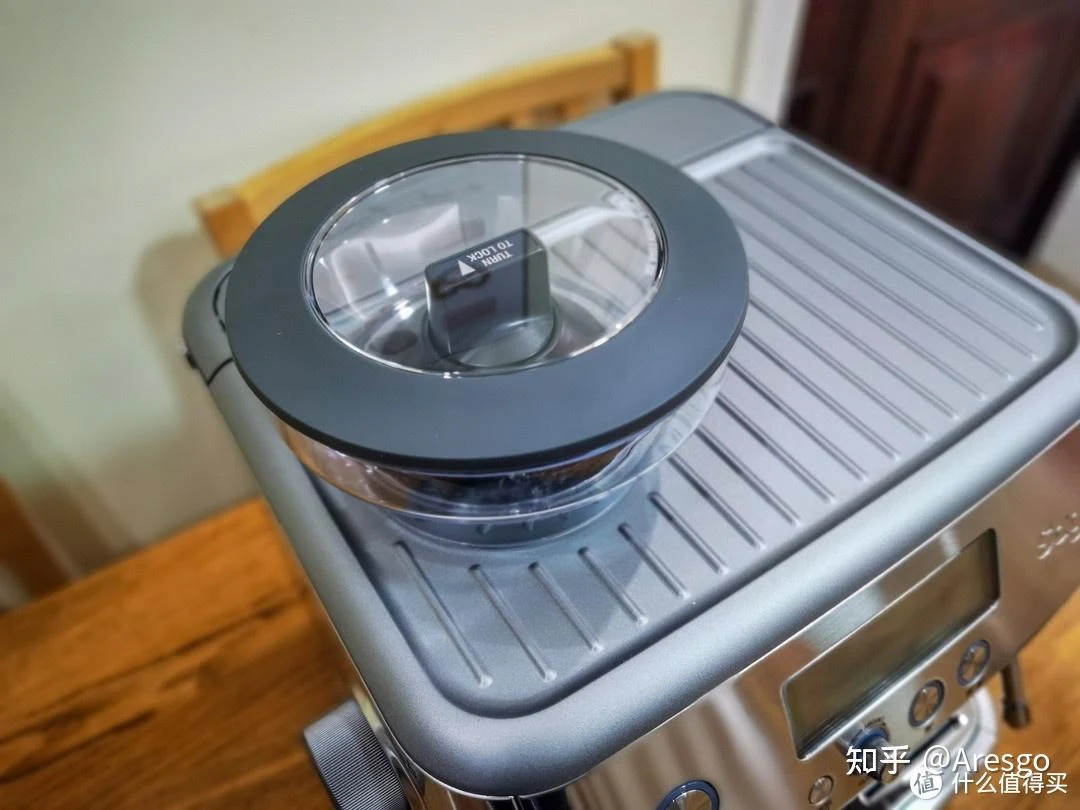 Top view of a stainless-steel Sage espresso machine showing its bean hopper and ridged warming tray.