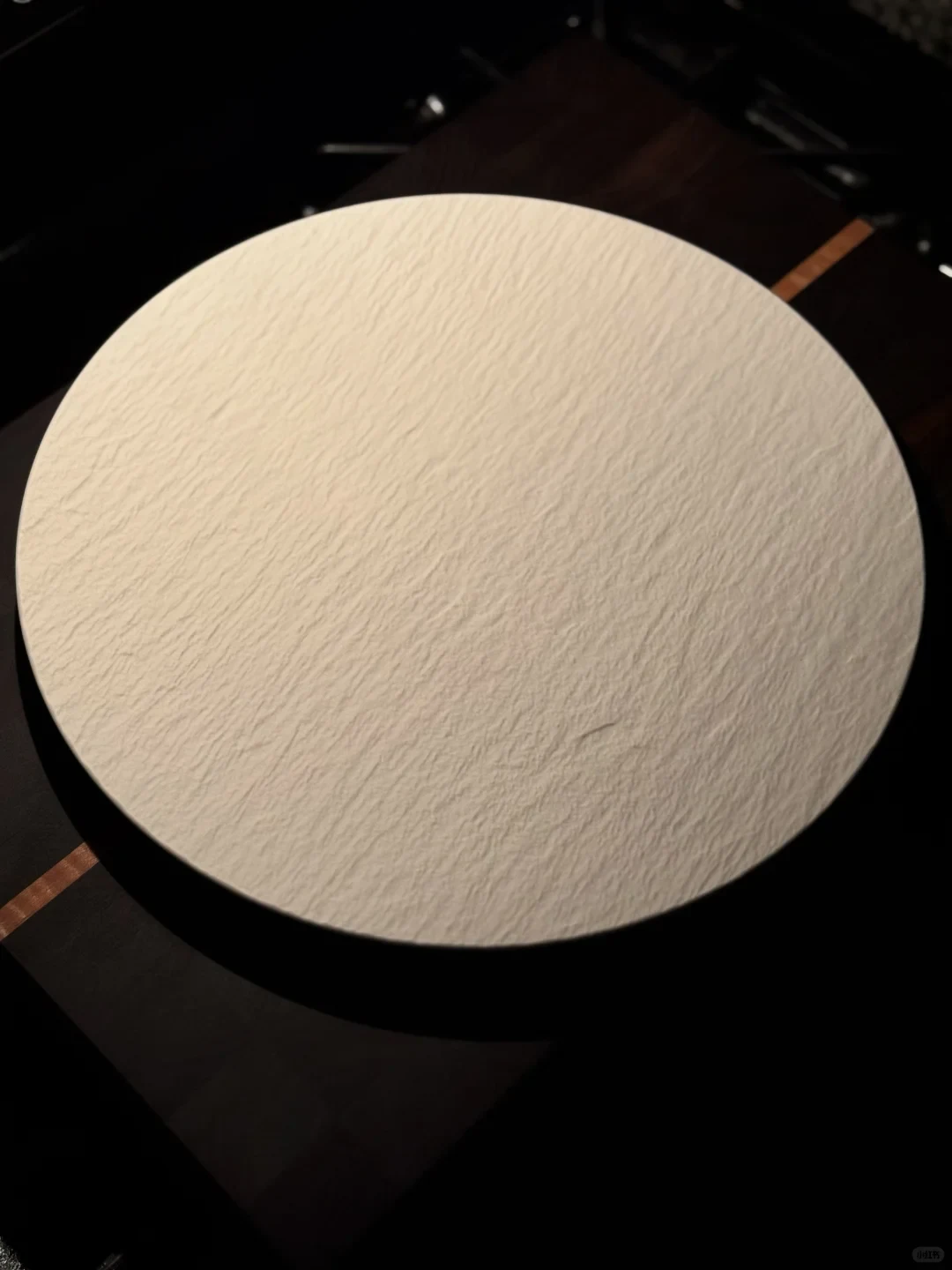 A large white plate with a textured surface rests on the dark kitchen counter.