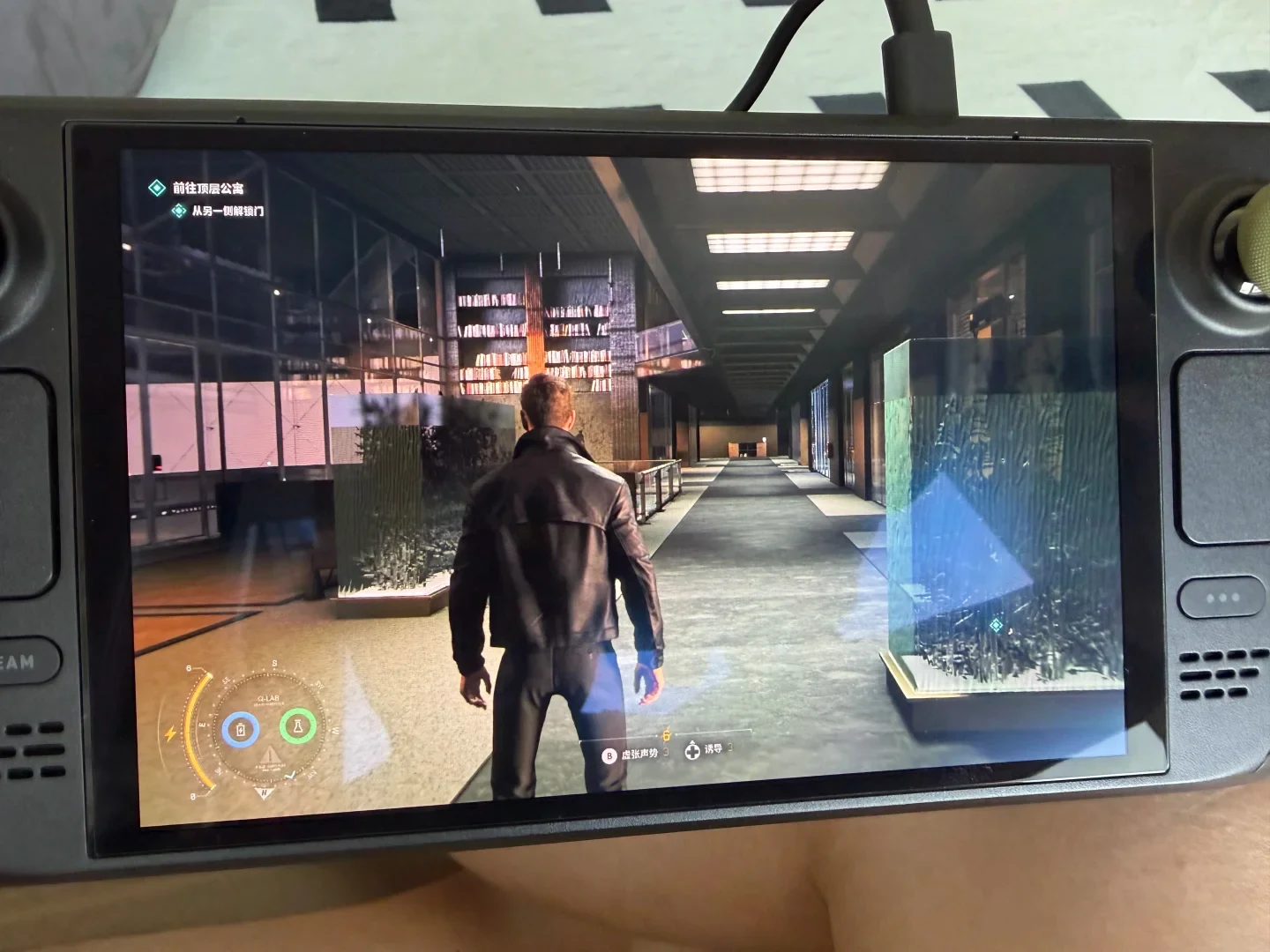 A Steam Deck handheld gaming console displaying a third-person video game set in a modern indoor hallway with bookshelves and large glass aquariums.