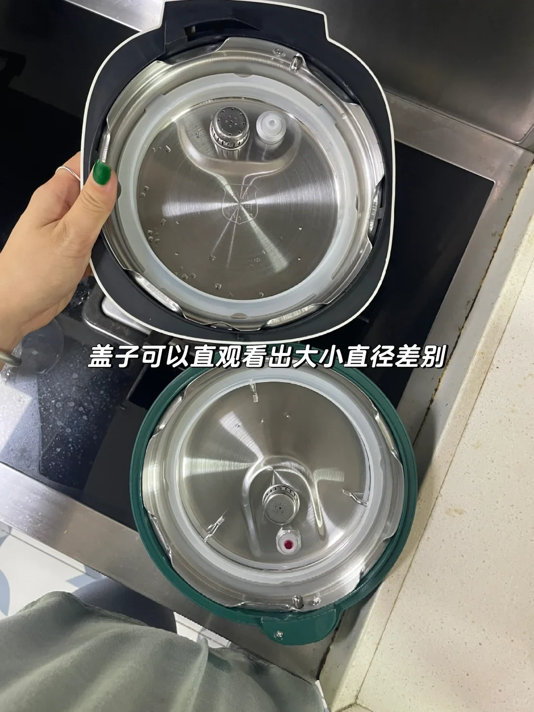 Two electric pressure cooker lids shown from the inside to compare their sizes, with a larger black lid held above a smaller green lid.