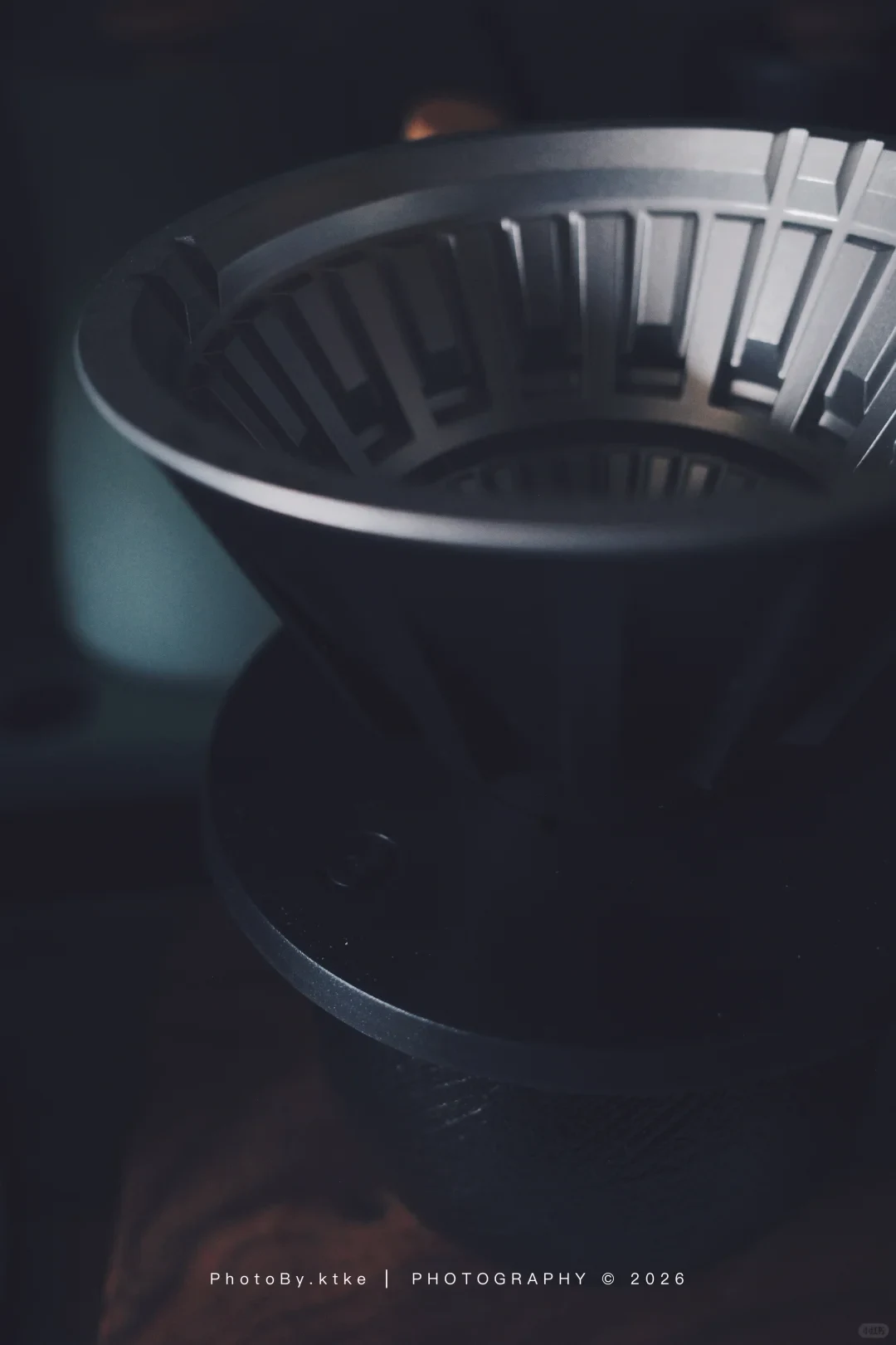 The metal VECTOR brewing cone sits inside its black sleeve over a dark cup.