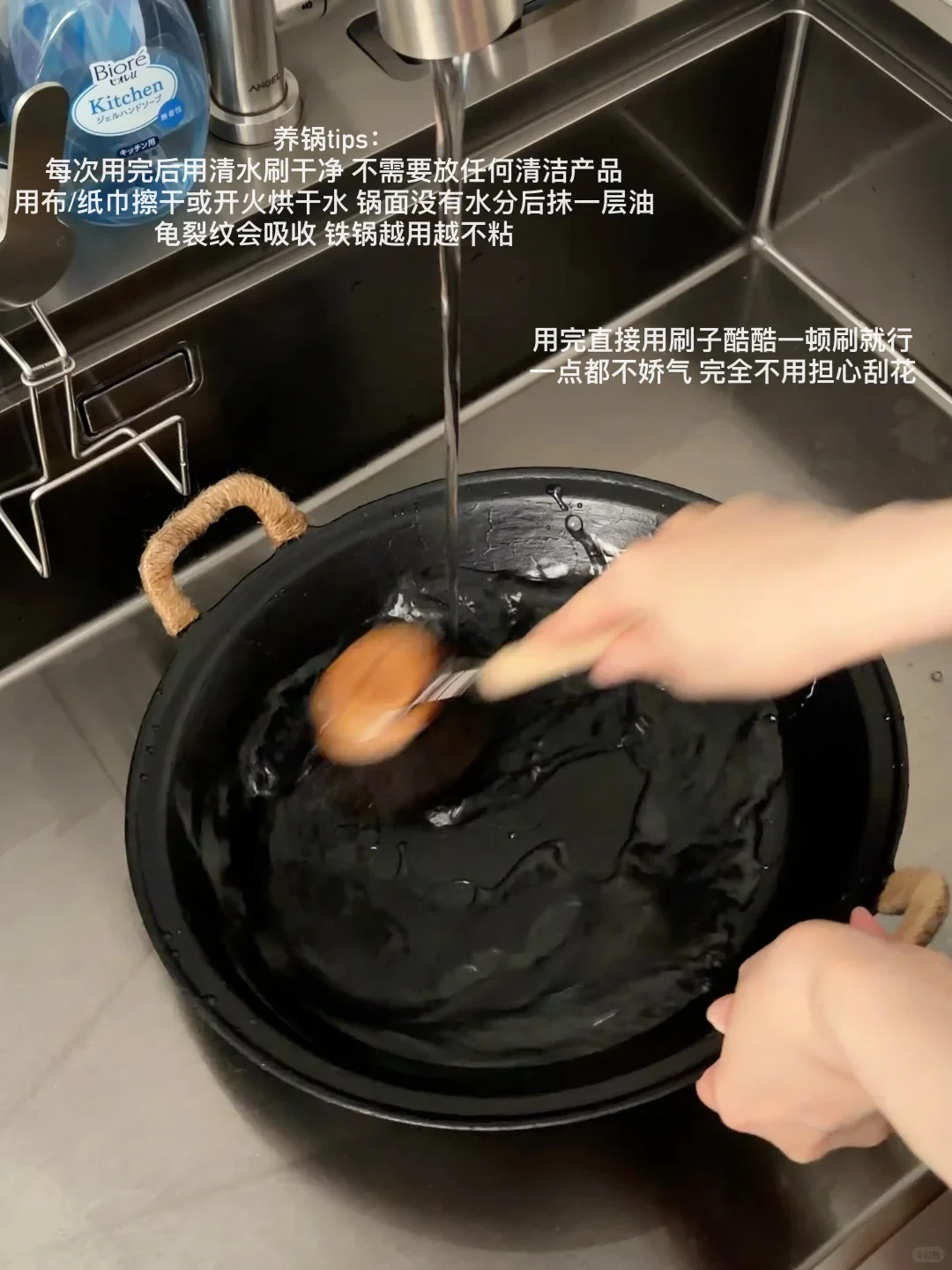 A person scrubs a black cast iron pot under running tap water in a kitchen sink, with instructional text about pot care overlaid on the screen.