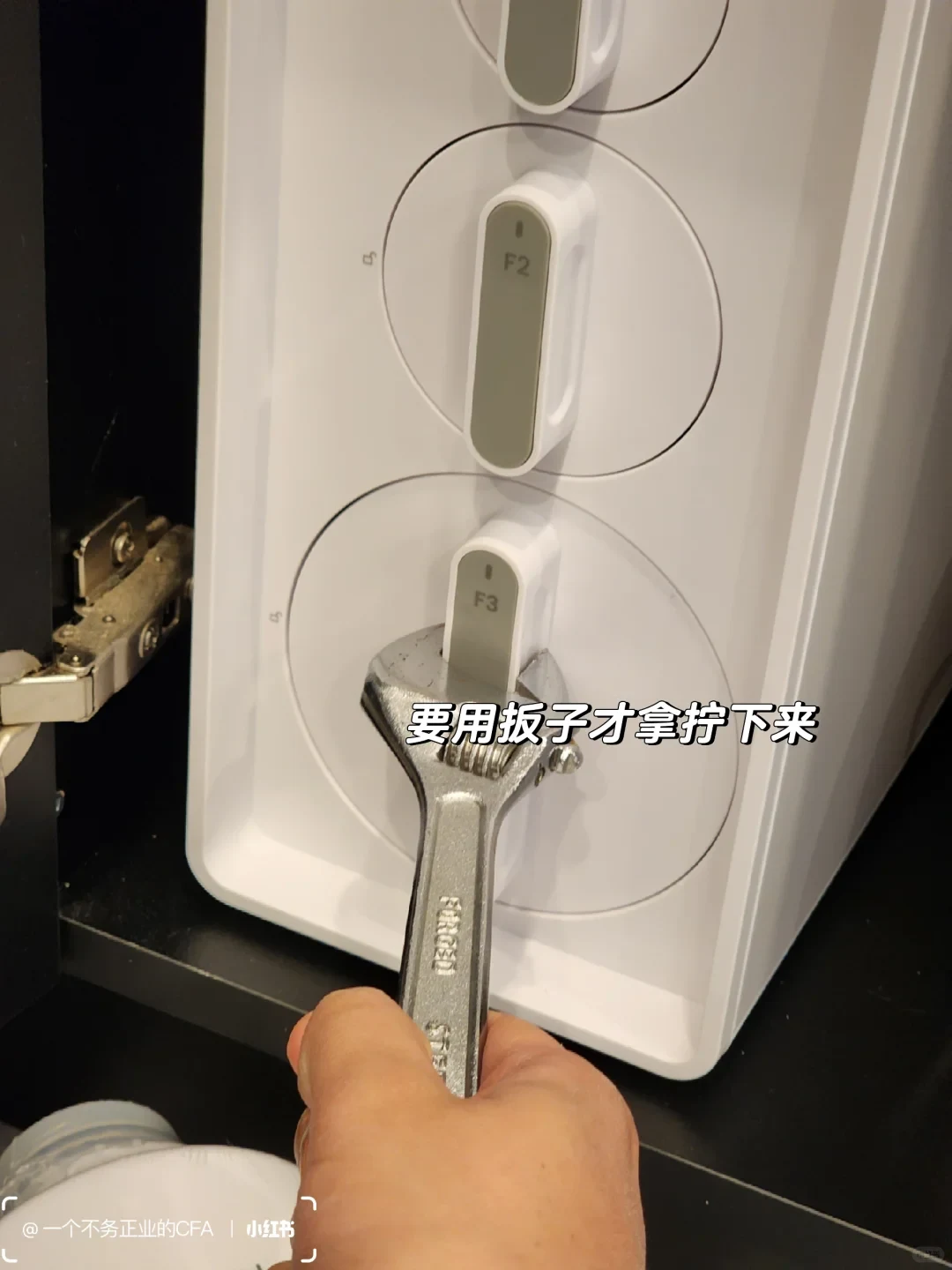 The owner uses an adjustable wrench on the X12 F3 filter handle, with the F2 handle visible above it. A Chinese caption says a wrench was needed to loosen and remove the cartridge.