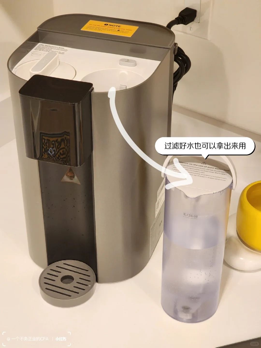 The C1H’s clear internal pure-water pitcher, marked 1 L/34 oz, is set beside the dispenser after removal. An arrow and Chinese bubble explain that it can be taken out for pouring.
