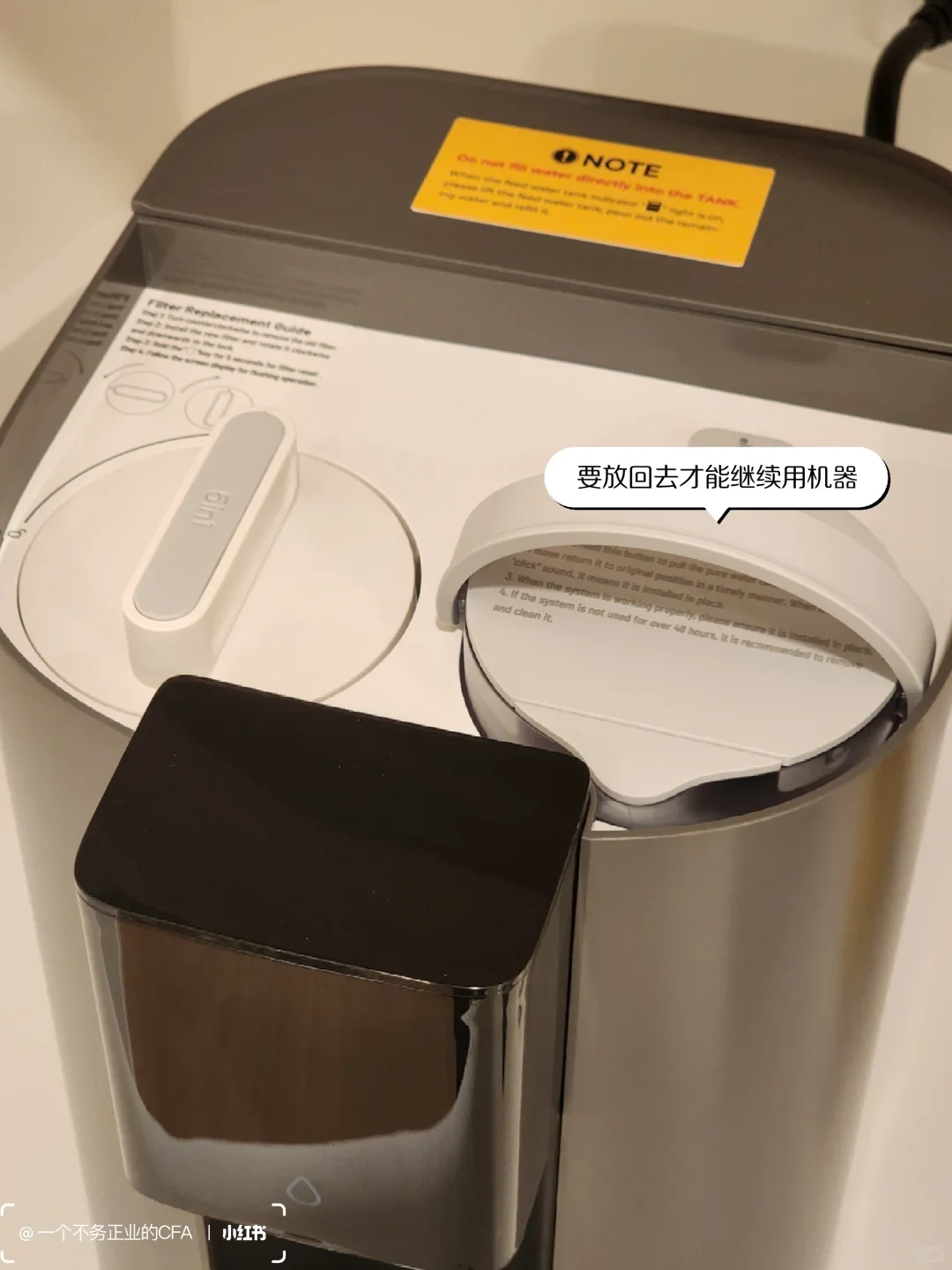 With the C1H top cover removed, the internal pure-water pitcher is reinstalled beside the filter. A Chinese callout says it must be returned before the machine can continue operating.